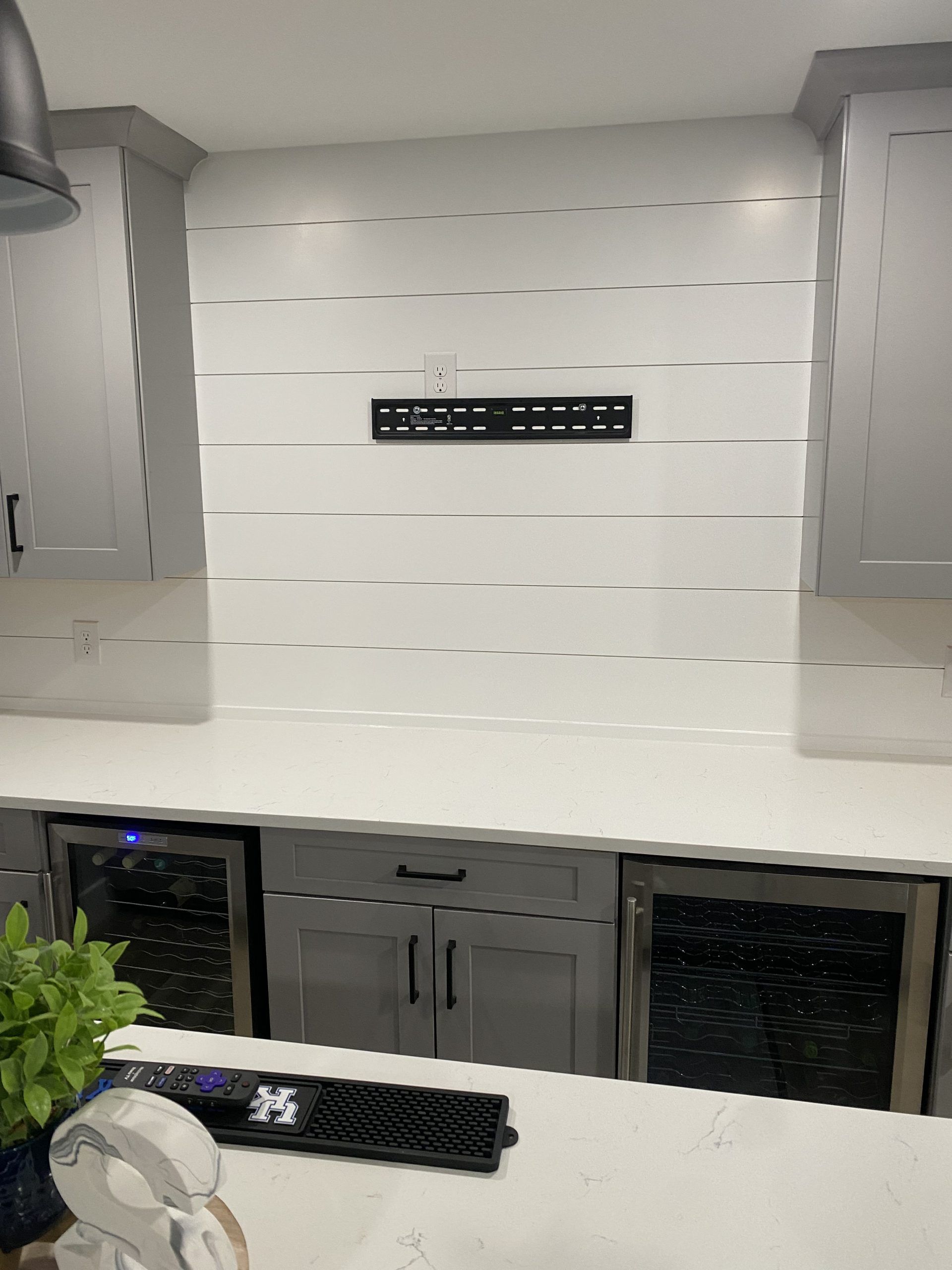 A kitchen with white cabinets and a wine cooler.