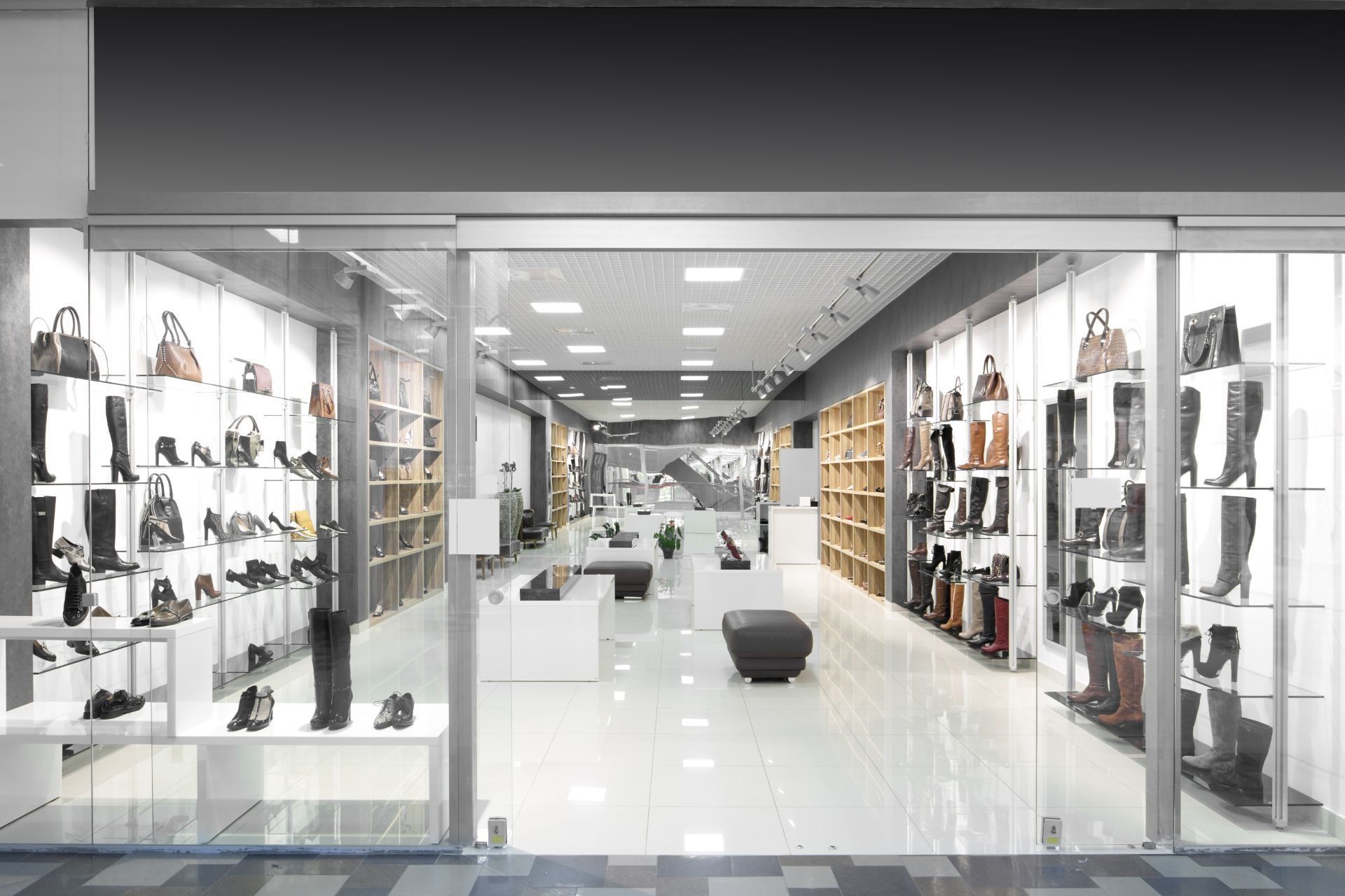 Bright, modern shoe store aisle with shelves of footwear and display cases on both sides