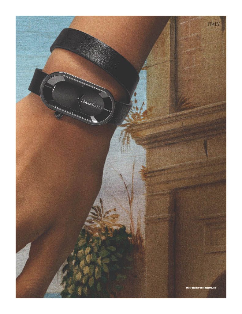 A matte black Ferragamo watch with a sleek, horizontal face on a tan woman's hand in front of a Renaissance-style painted landscape background