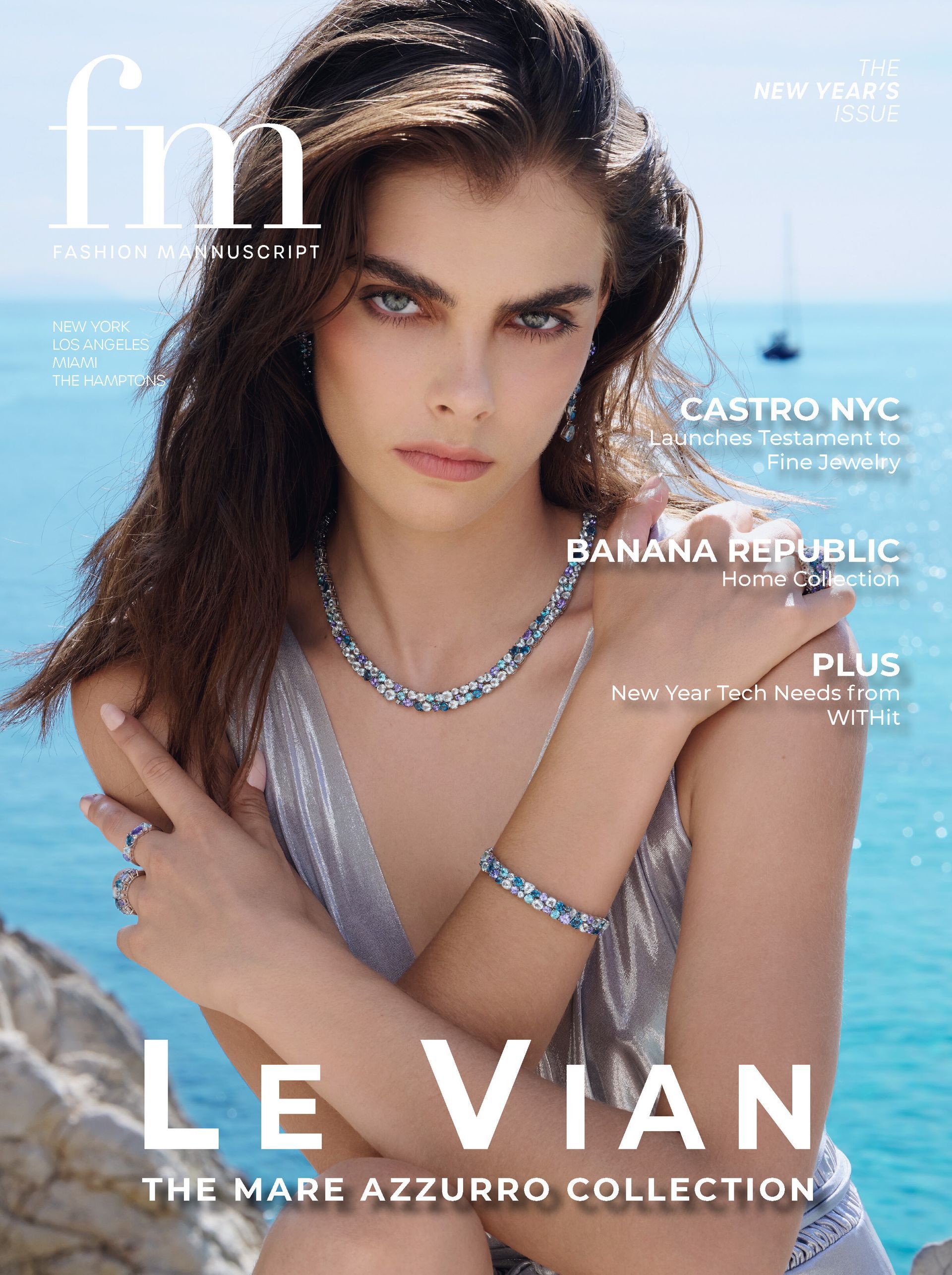 A brunette woman in blue and sapphire jewelry with her arms crossed over her chest in front of a turquoise blue sea