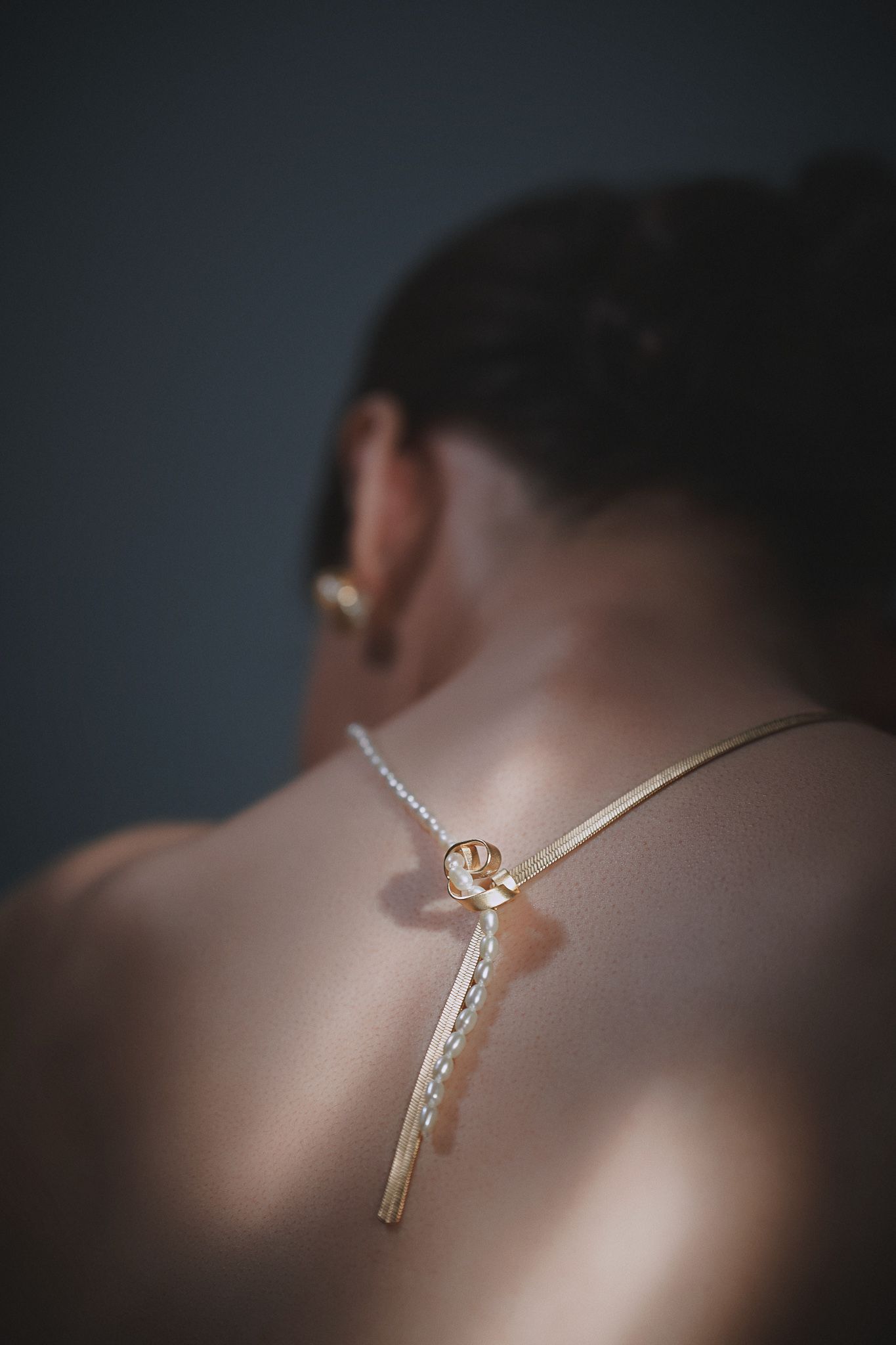 A diamond necklace down the center of a woman's bare back