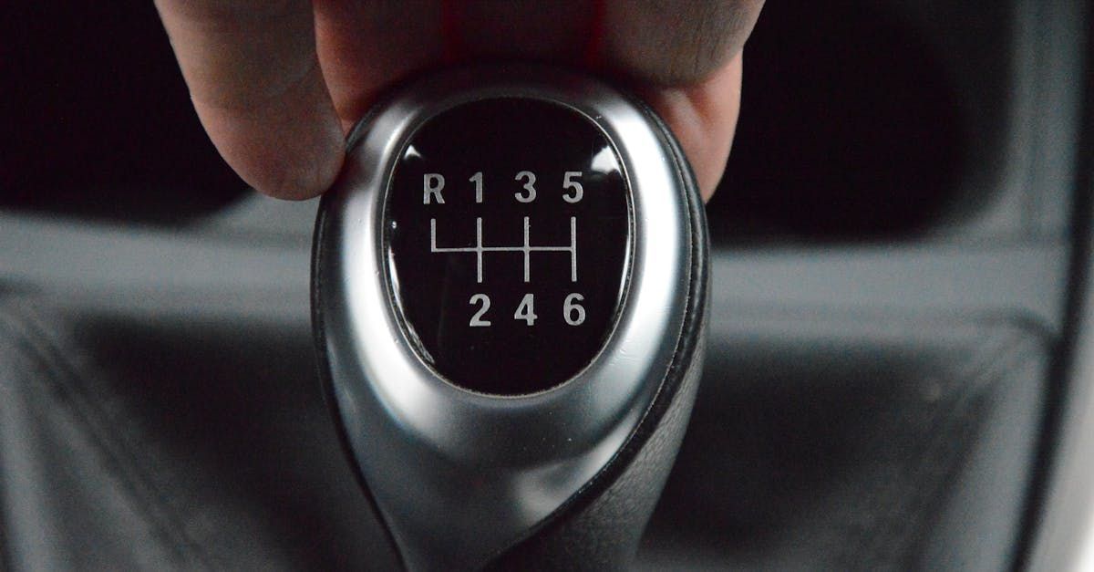 A person is holding a car shifter in their hand.  | Real Autohaus Automotive