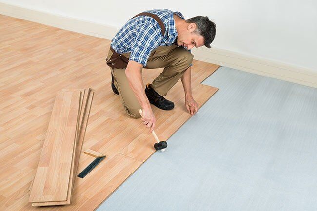 Man Installing New Wooden Floor — Floor Repair in Gales Ferry, CT