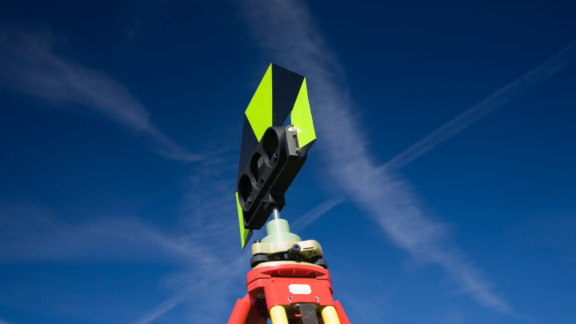A man is pouring concrete on a sidewalk with a shovel.