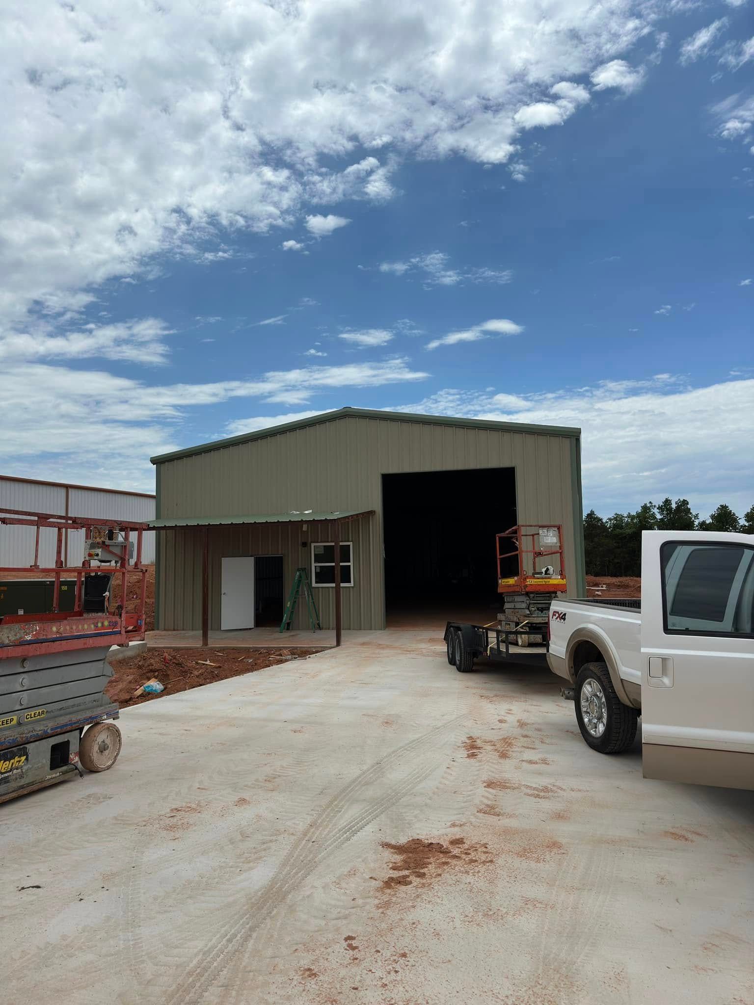 A white truck is parked in front of a building under construction.