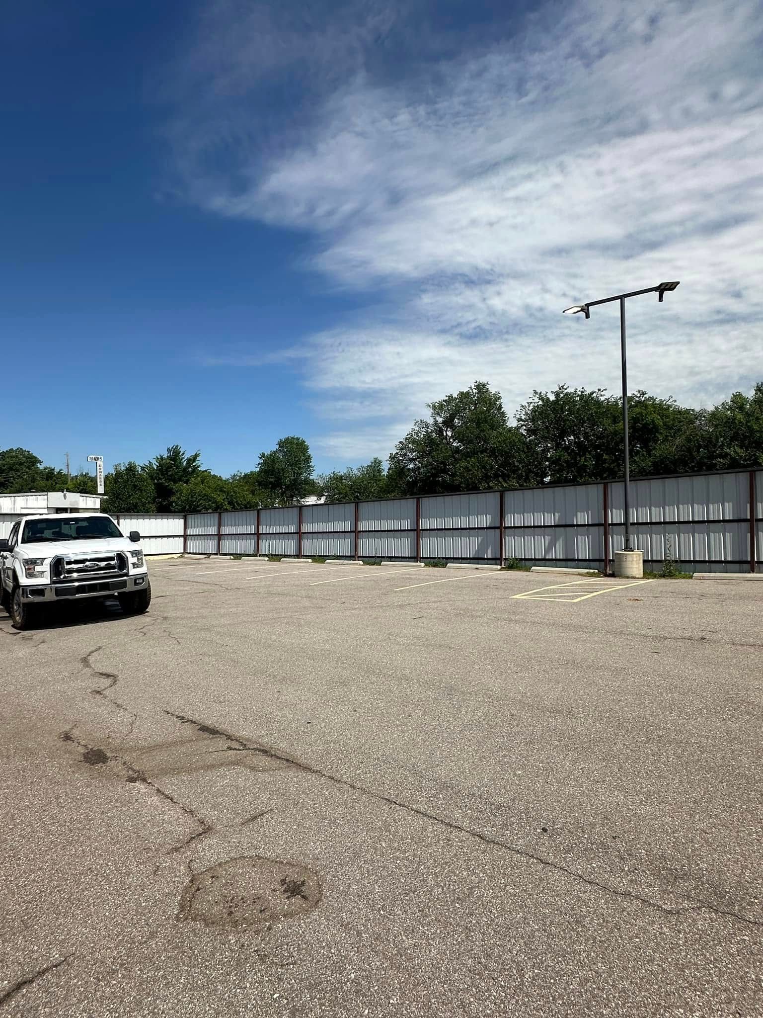 A white truck is parked in a gravel lot.