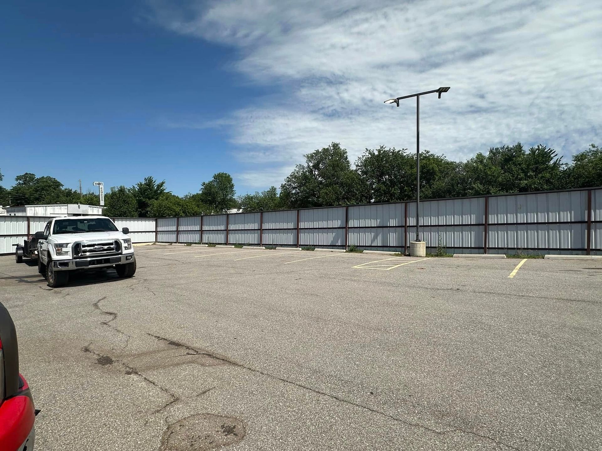 A white truck is parked in an empty parking lot