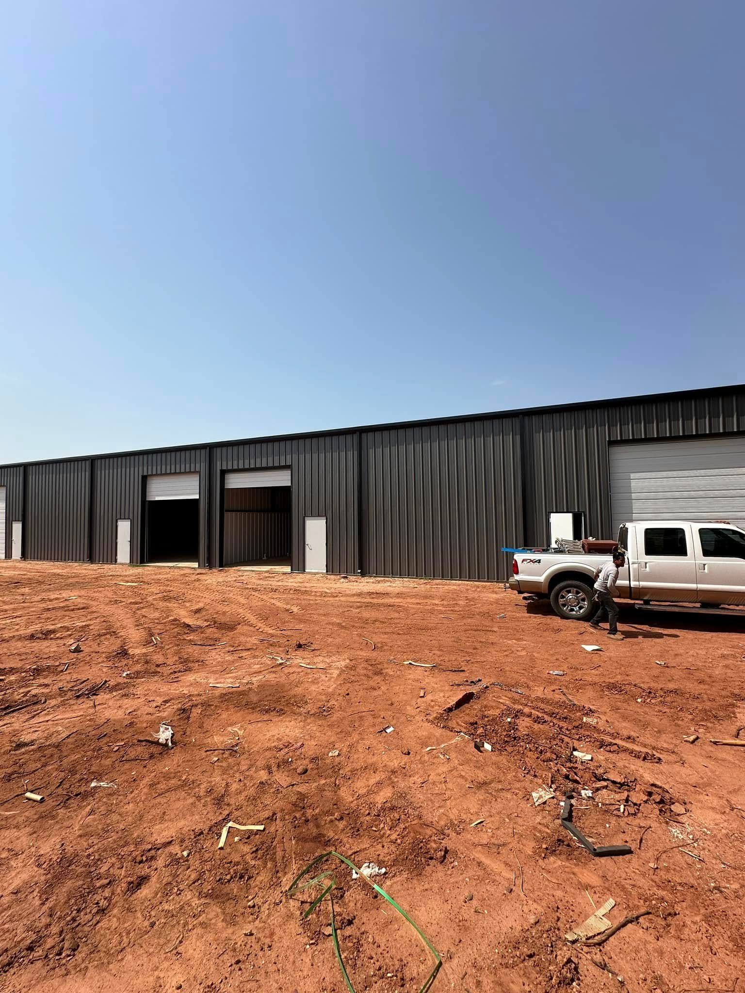 A white truck is parked in front of a large building.