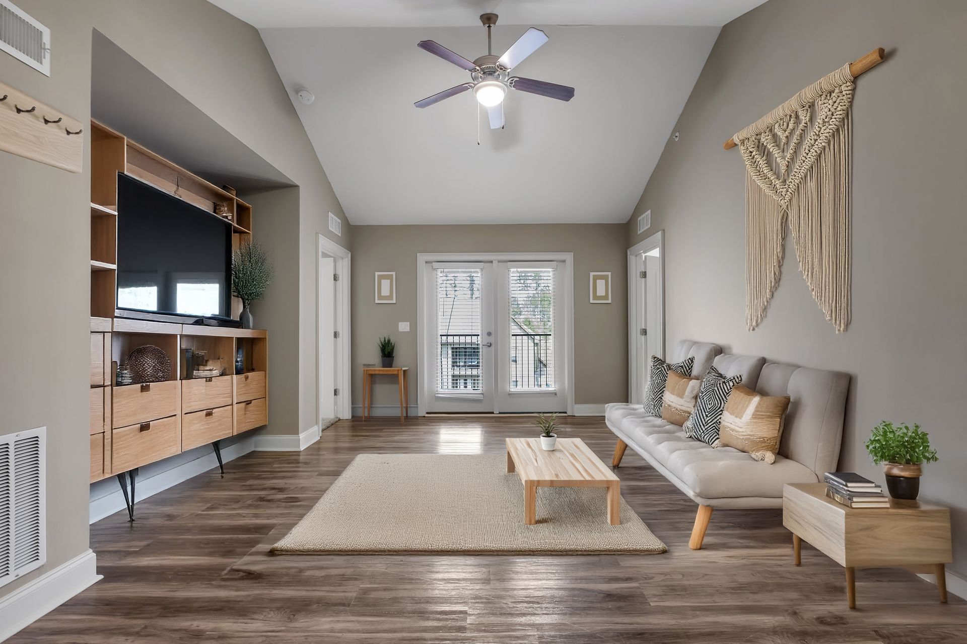 Spacious living room area with modern decor, high ceilings and sleek flooring.