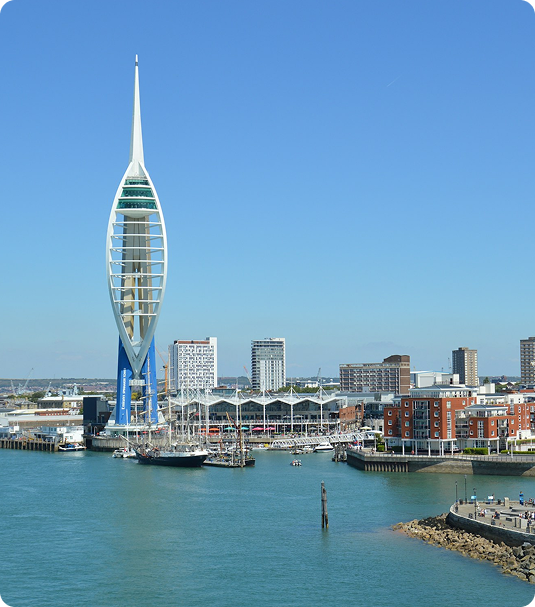 Spinnaker Tower overlooking Portsmouth harbor with boats and waterfront buildings under a clear blue sky