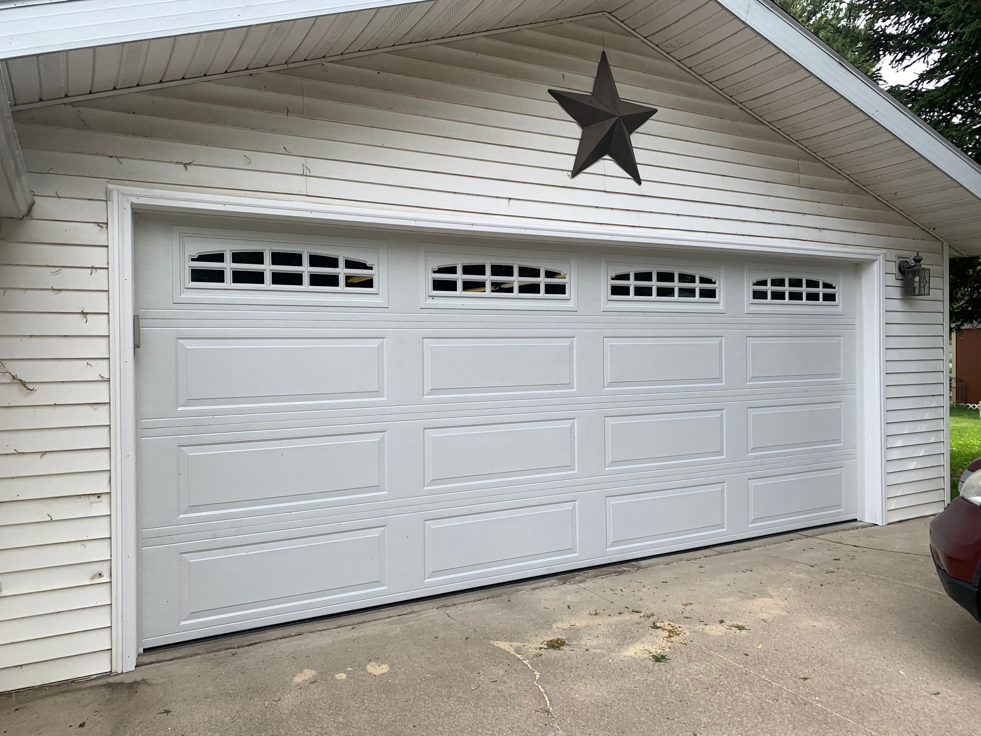 White garage door with window panels, star decor above.