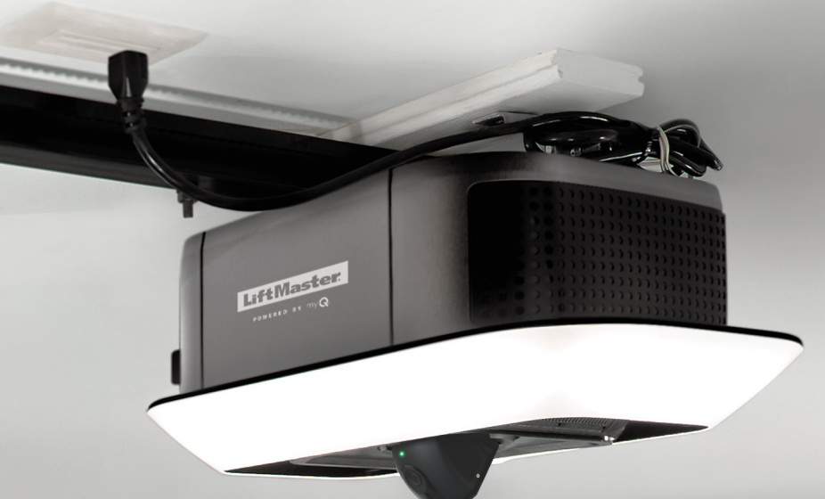 Gray LiftMaster garage door opener attached to the ceiling with a bright white light.