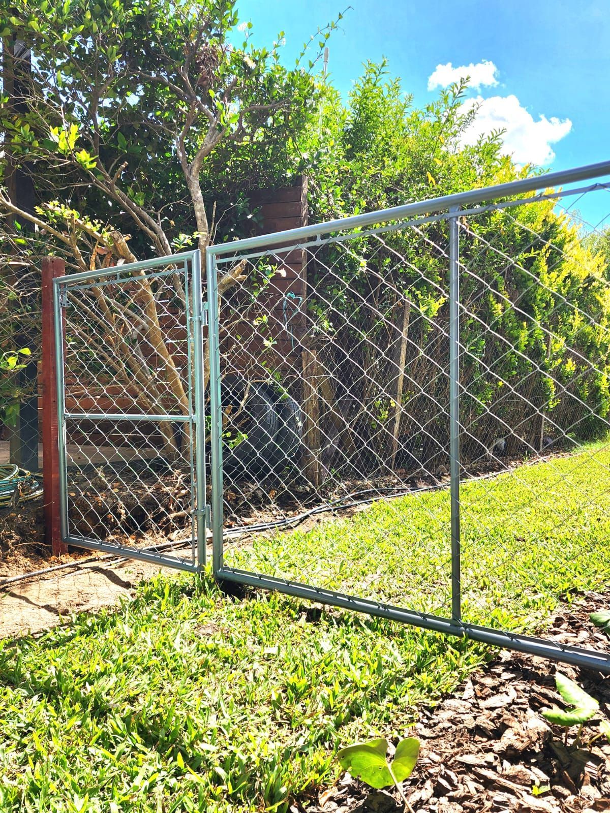 Una valla con muchos alambres y un cielo azul al fondo.