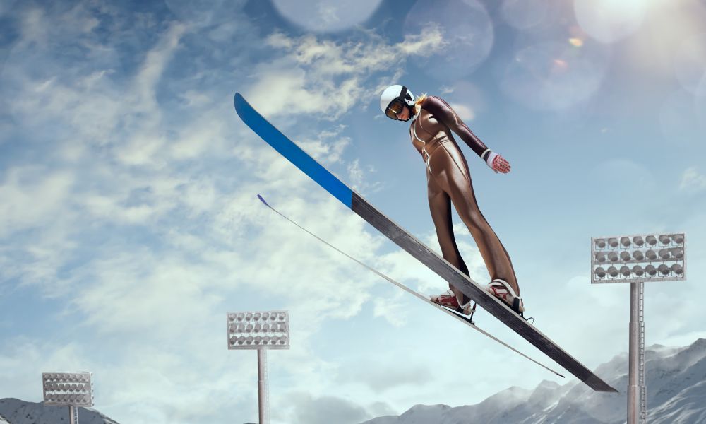 A ski jumper is jumping in the air while wearing a helmet.