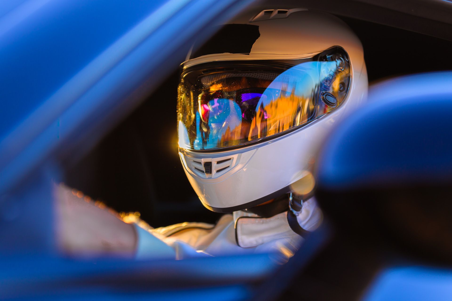 A man wearing a helmet and goggles is driving a car.