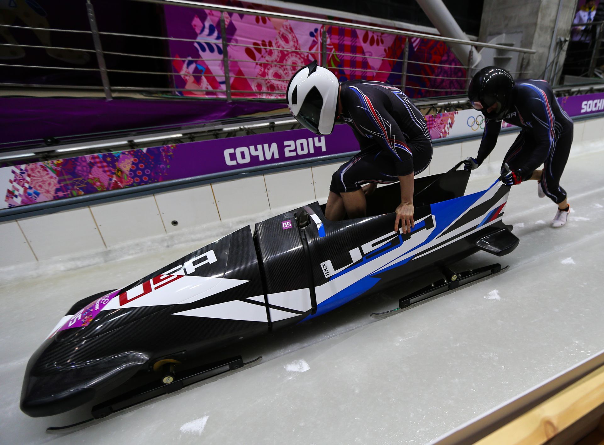A couple of people are riding a sled that says usa on it