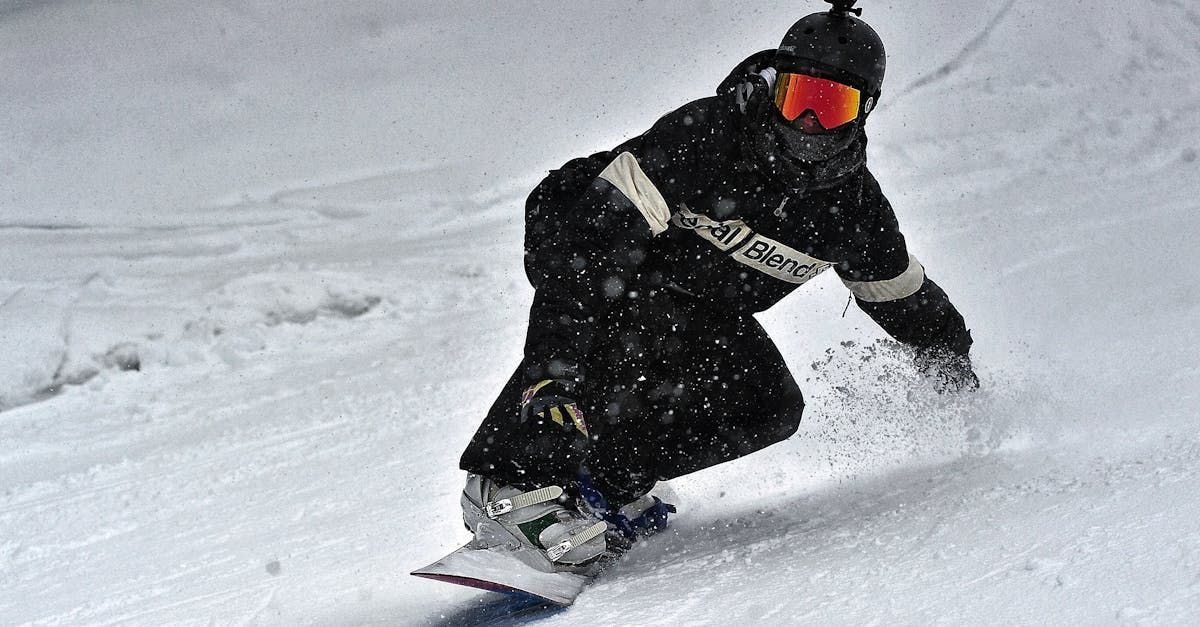 A person is riding a snowboard down a snow covered slope.