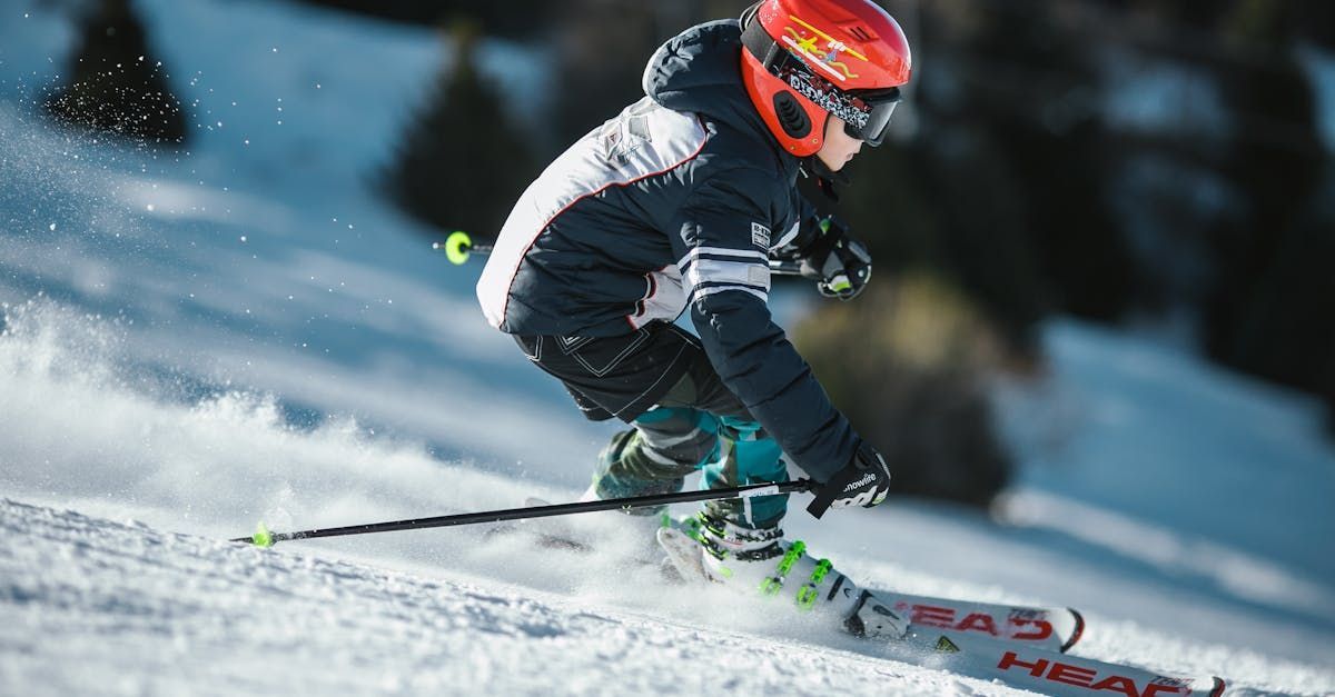 A young boy is skiing down a snow covered slope.