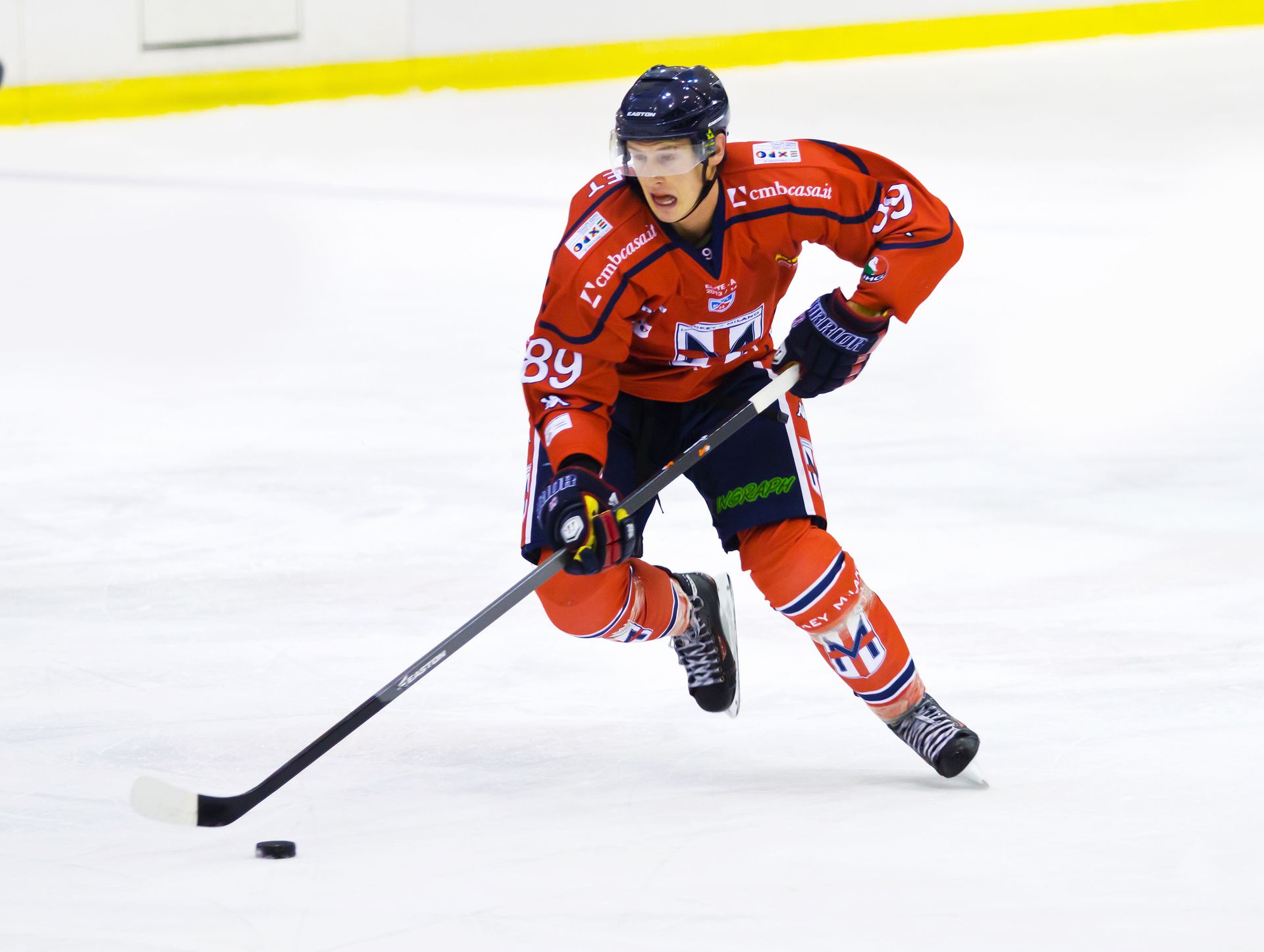 Two young boys are playing ice hockey on a rink.