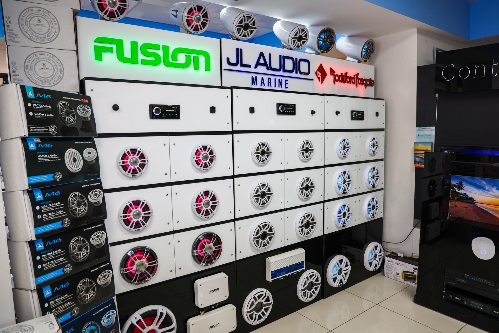 A store filled with lots of speakers and a sign that says fusion jl audio
