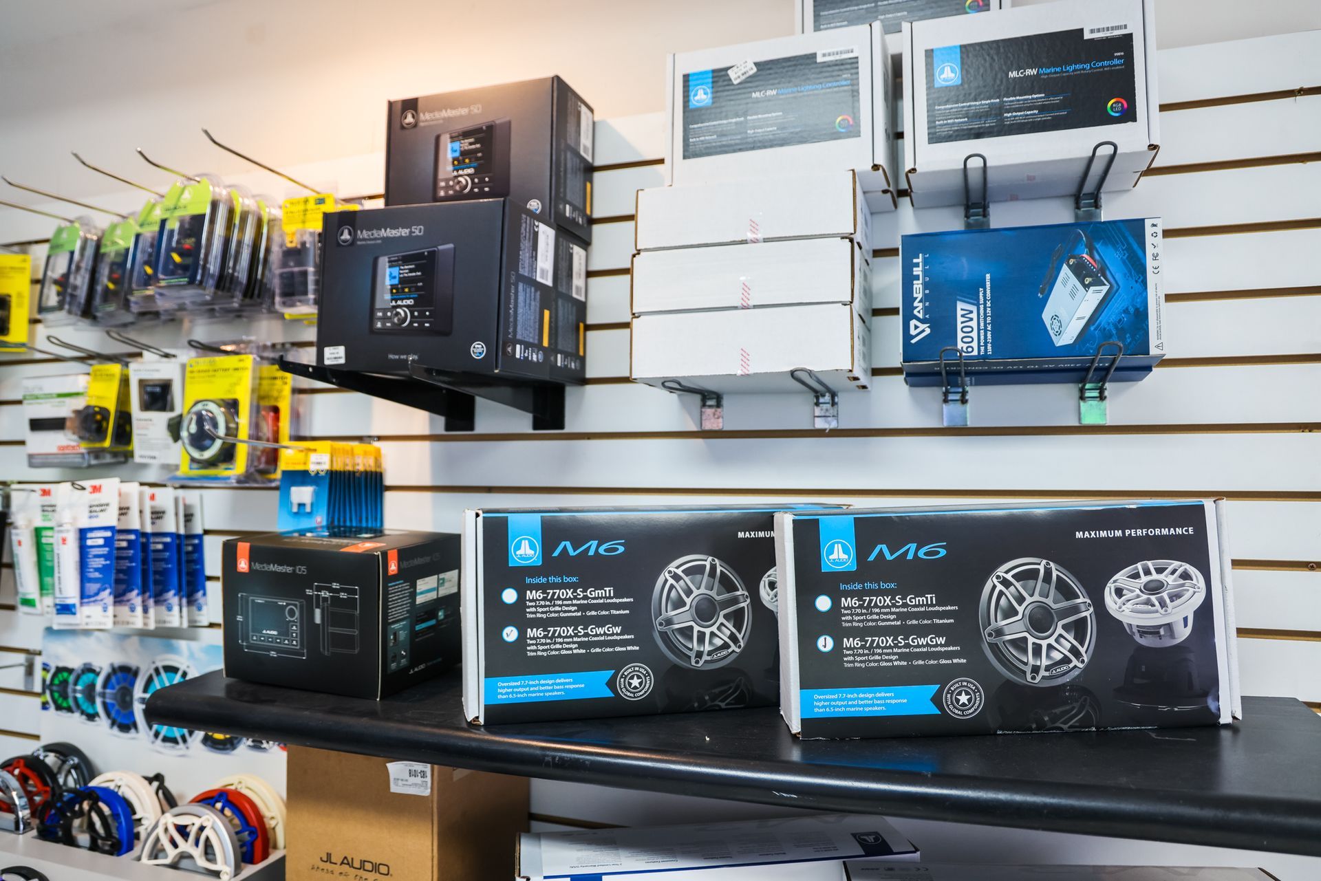 A shelf filled with boxes of electronics and a wall with boxes on it.