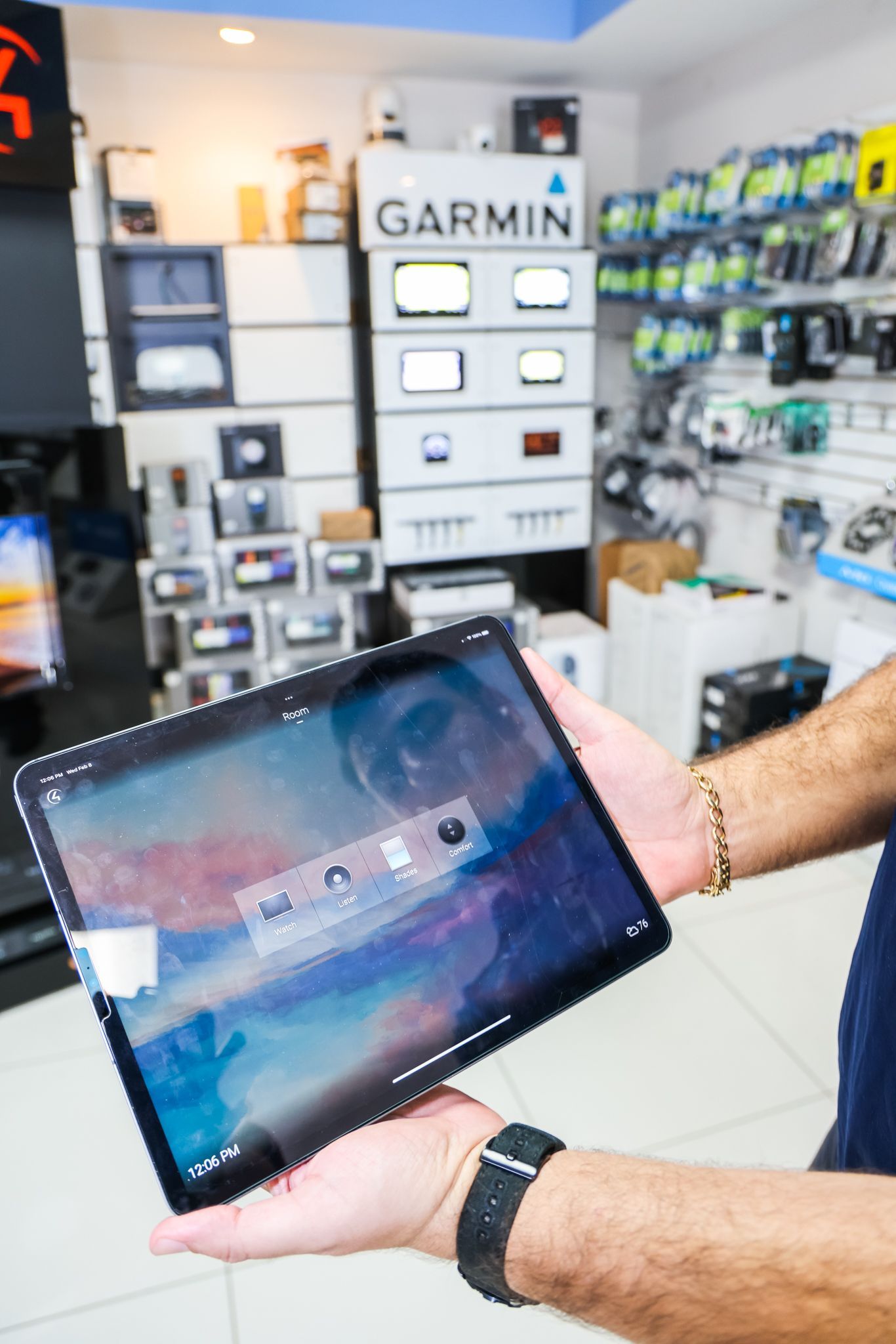 A man is holding a tablet in his hands in a store.