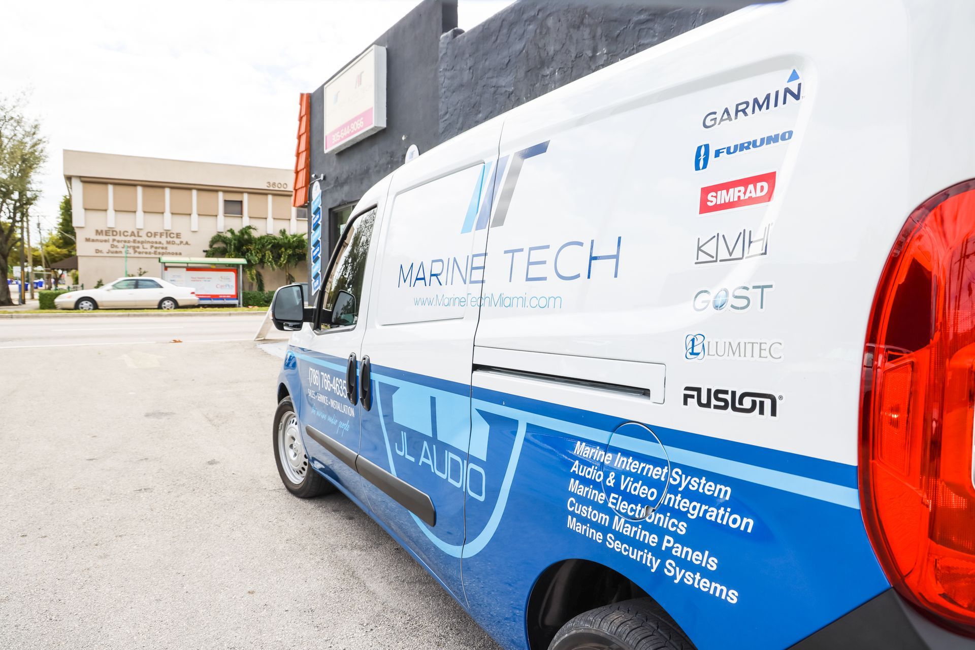 A blue and white van is parked in front of a building.