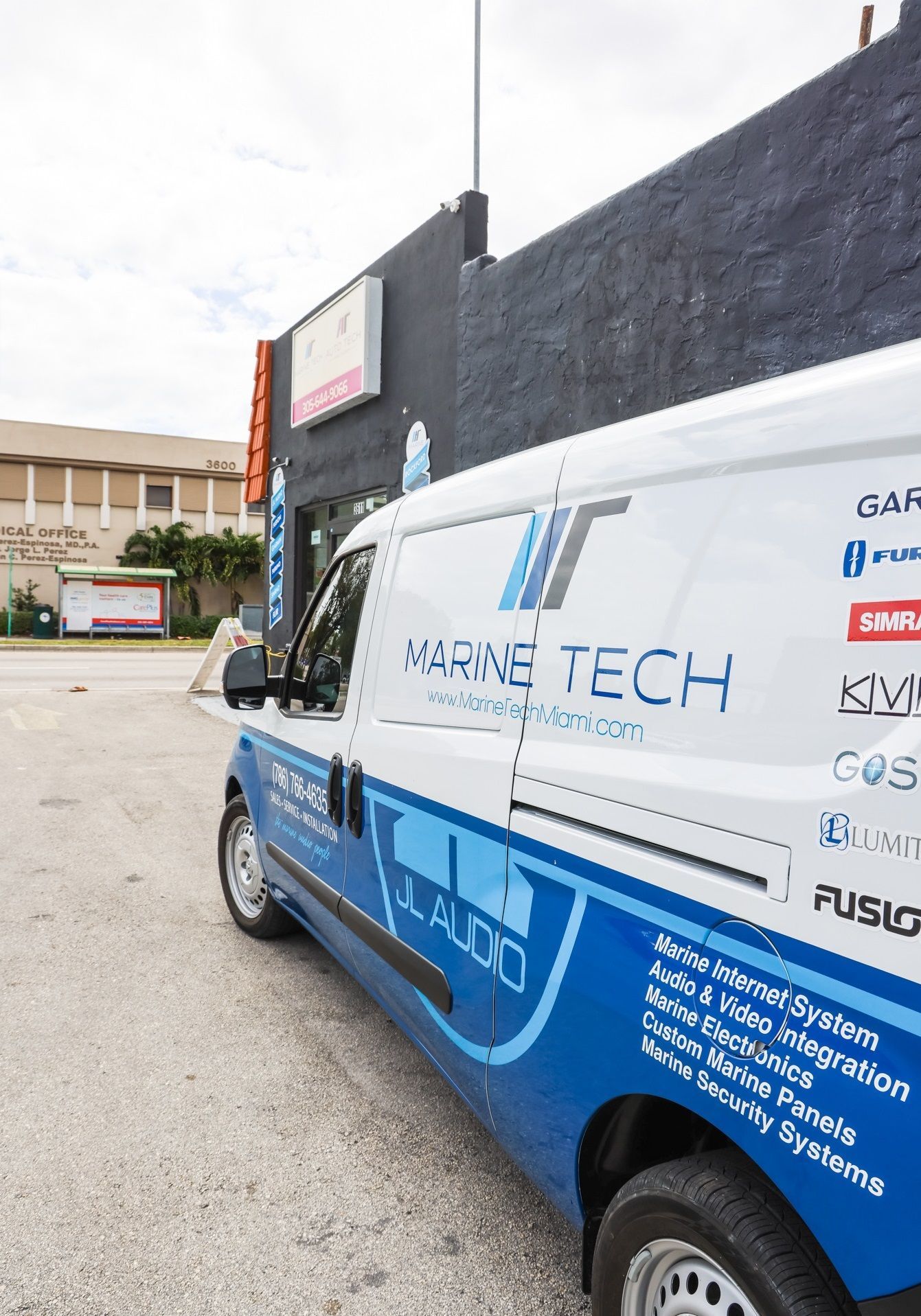 A blue and white van is parked in front of a building.