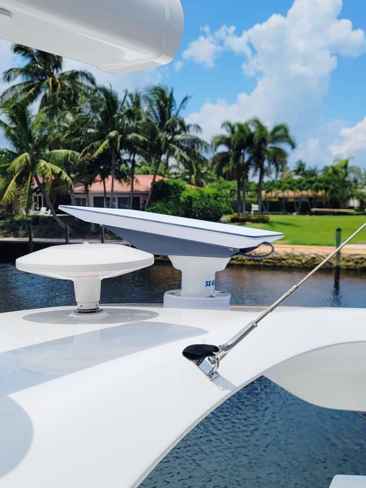 A white boat is floating on a body of water with palm trees in the background