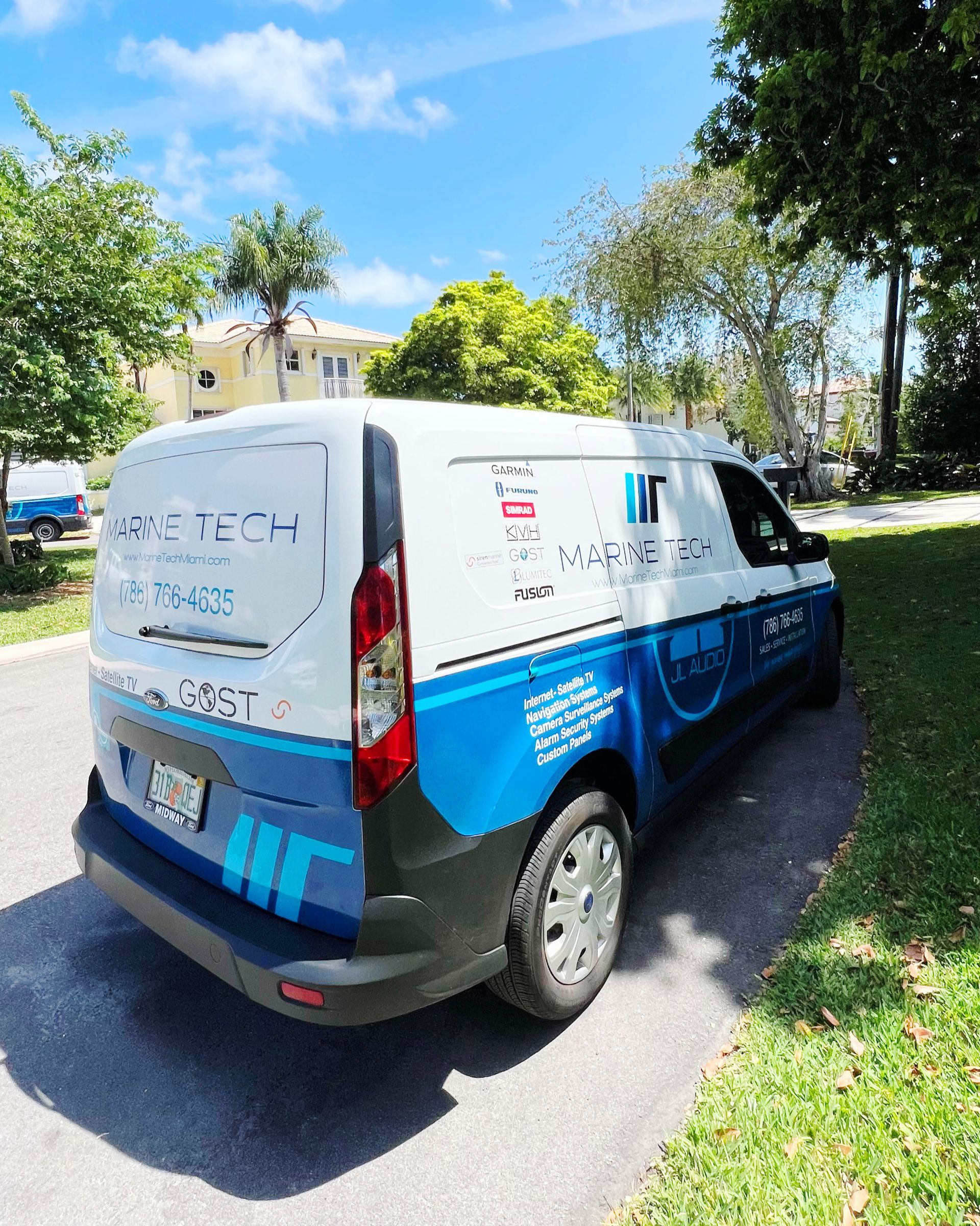 A blue and white van is parked on the side of the road.