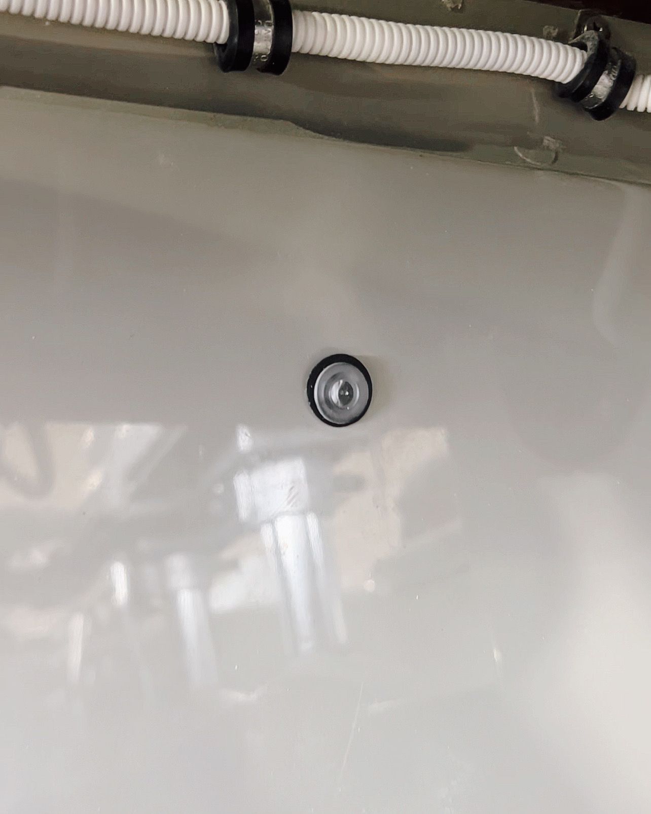 A white wall with a screw in the middle of it.