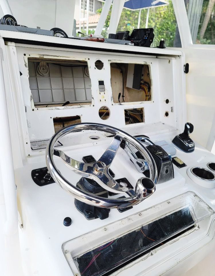 A white boat with a steering wheel on top of it