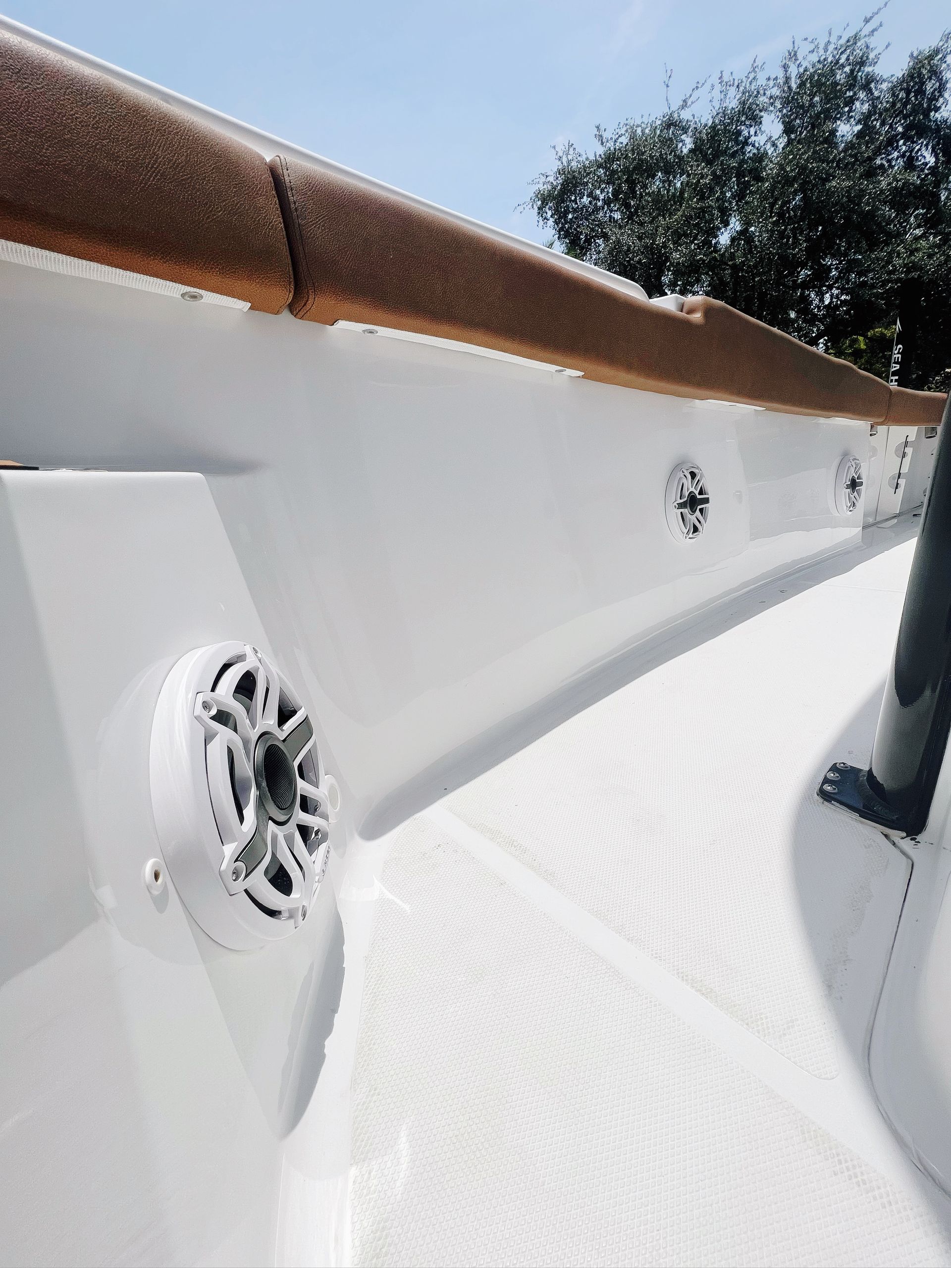 A white boat with speakers on the side of it