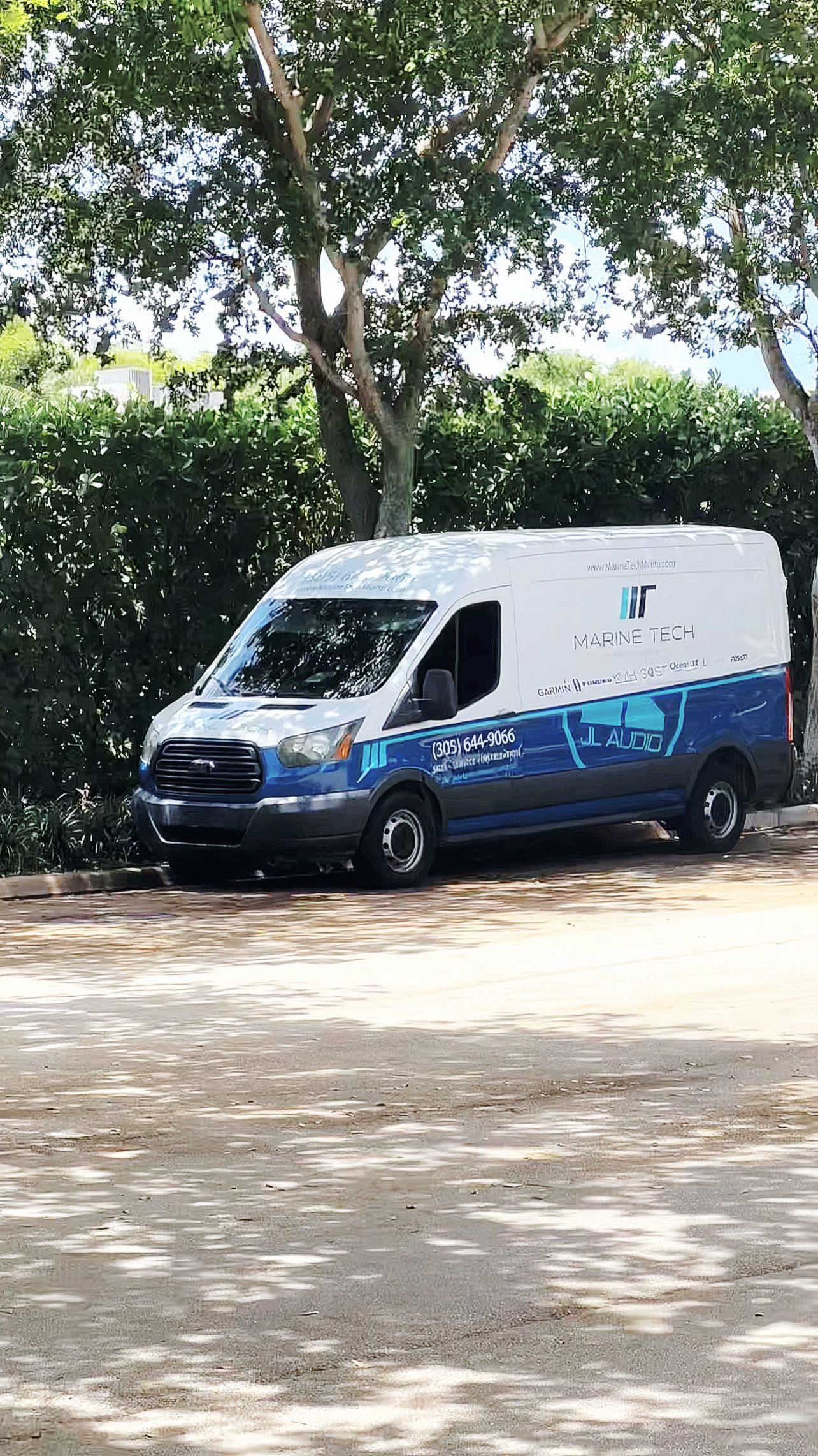A blue and white van is parked in a parking lot.