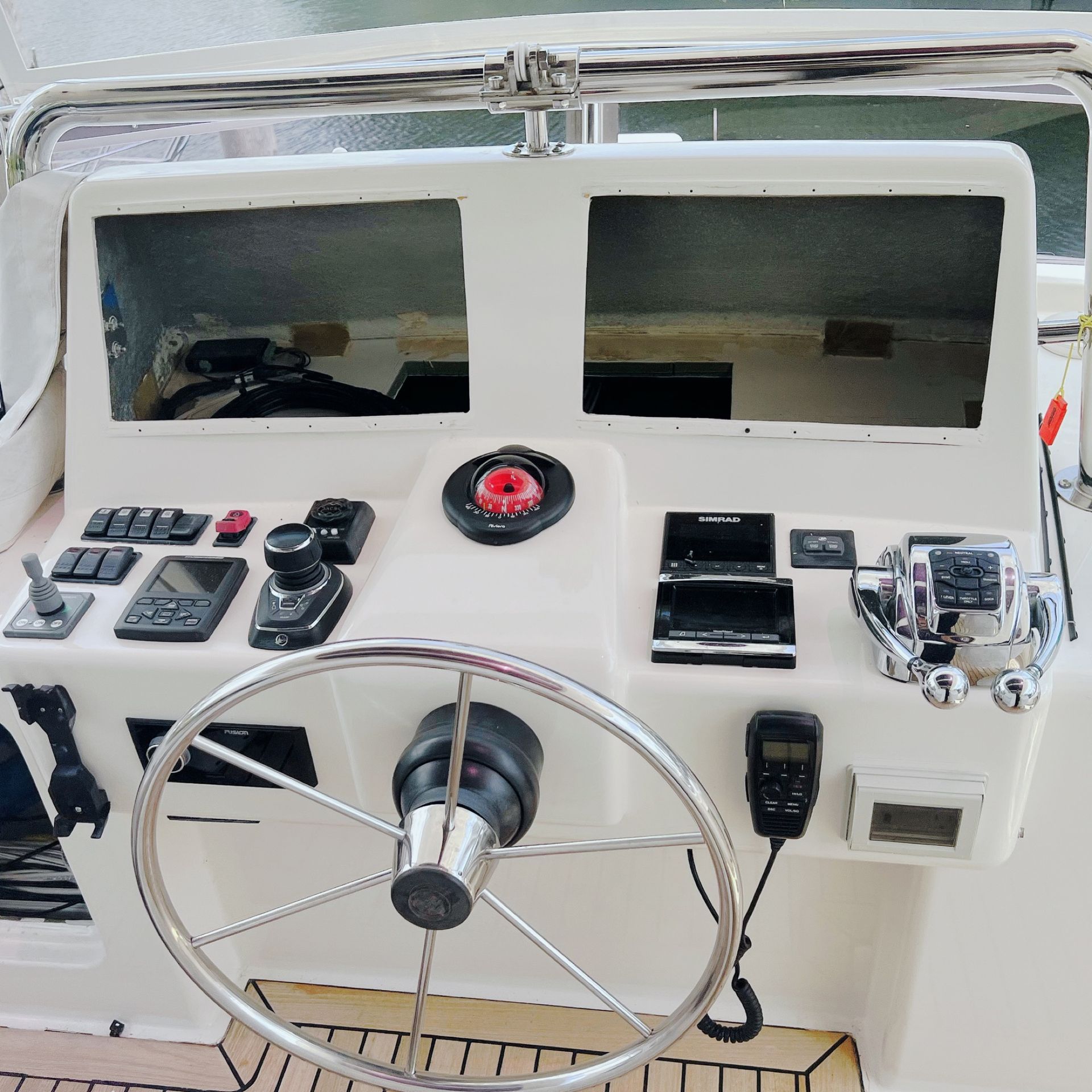 The steering wheel of a boat has a red button on it