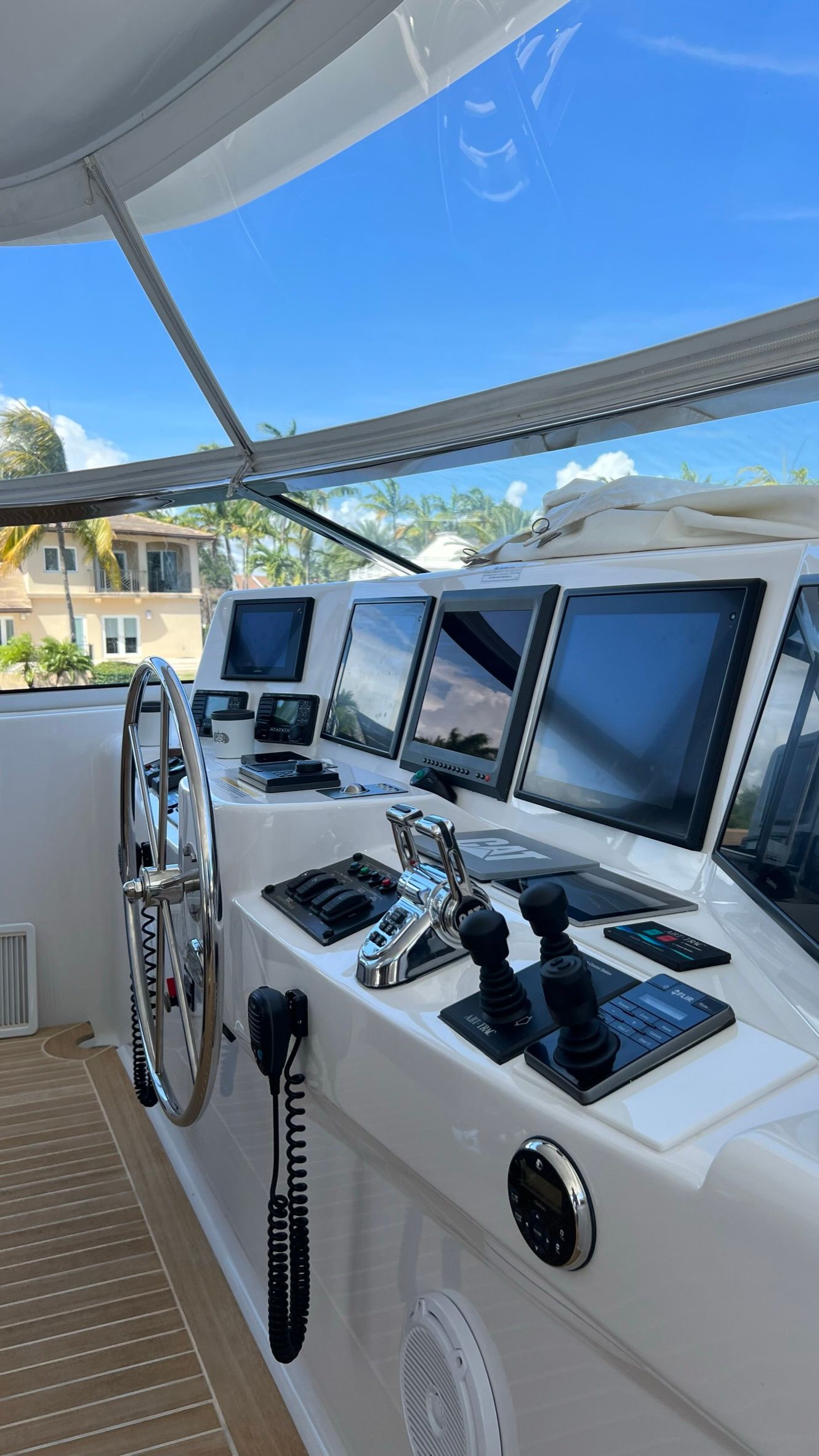 The cockpit of a boat with a lot of monitors and controls.