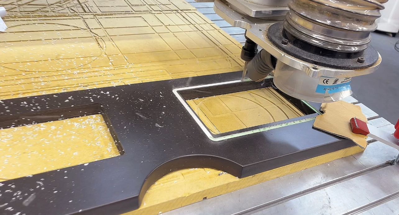 A machine is cutting a piece of wood on a table.