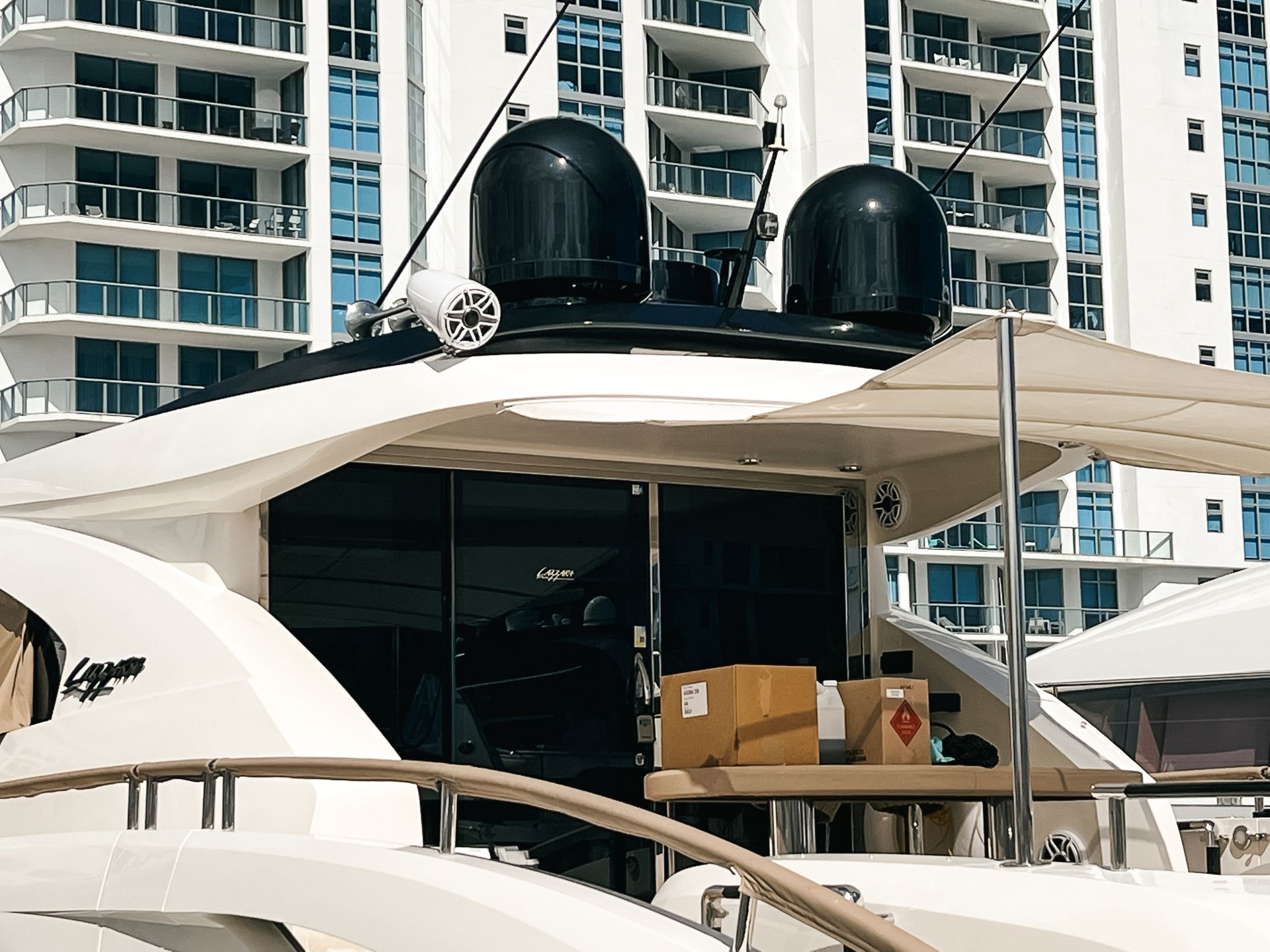 A boat with boxes on the deck and a building in the background