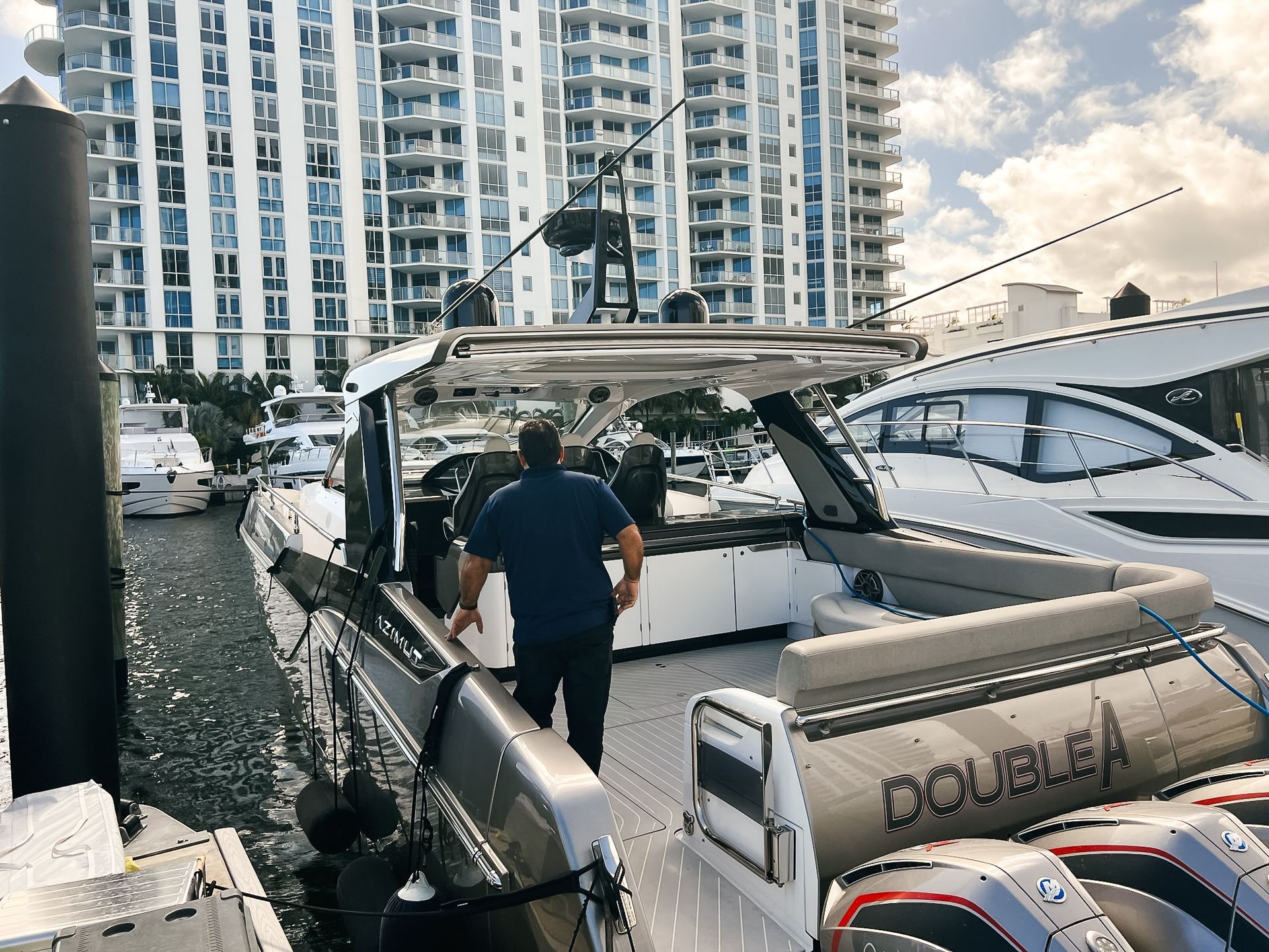 A man is standing on the deck of a boat that says docua