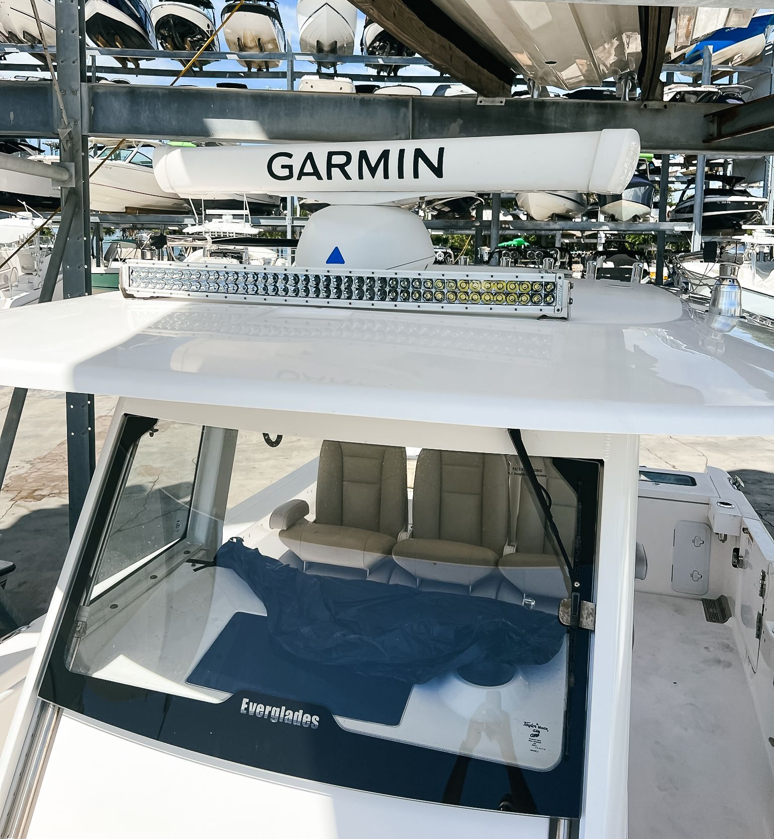 A white boat with a garmin antenna on top of it
