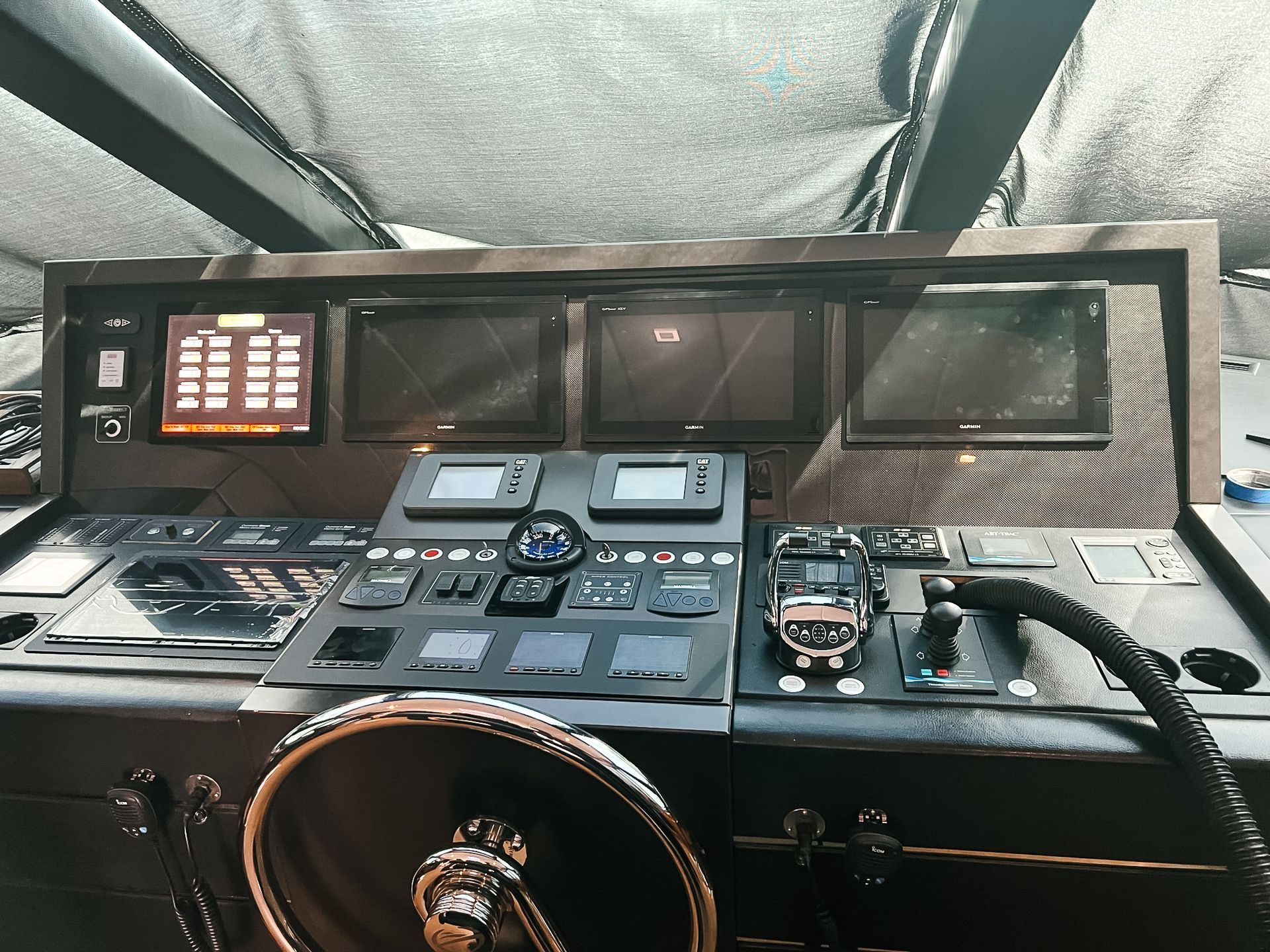 A steering wheel and control panel on a boat