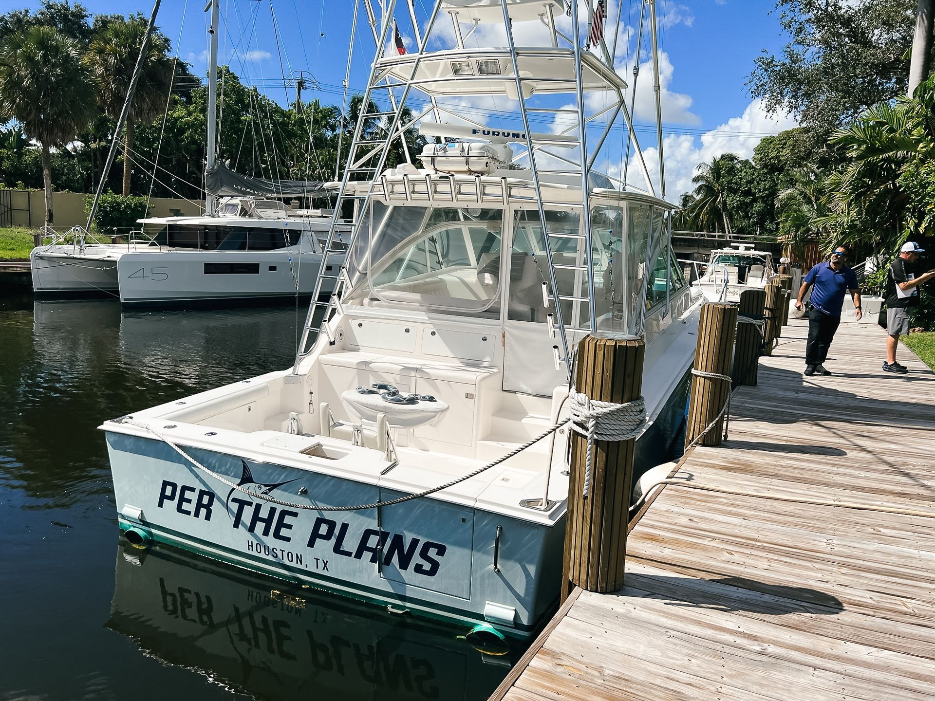 A boat called per the plans is docked at a dock.