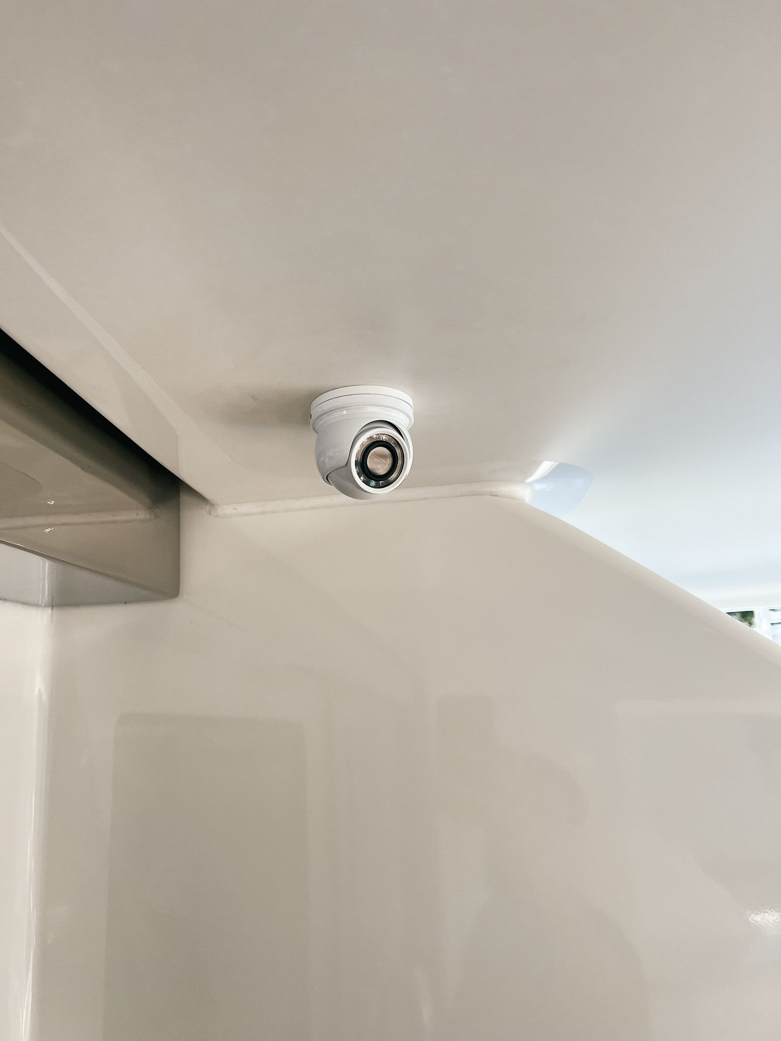 A security camera is hanging from the ceiling of a room.