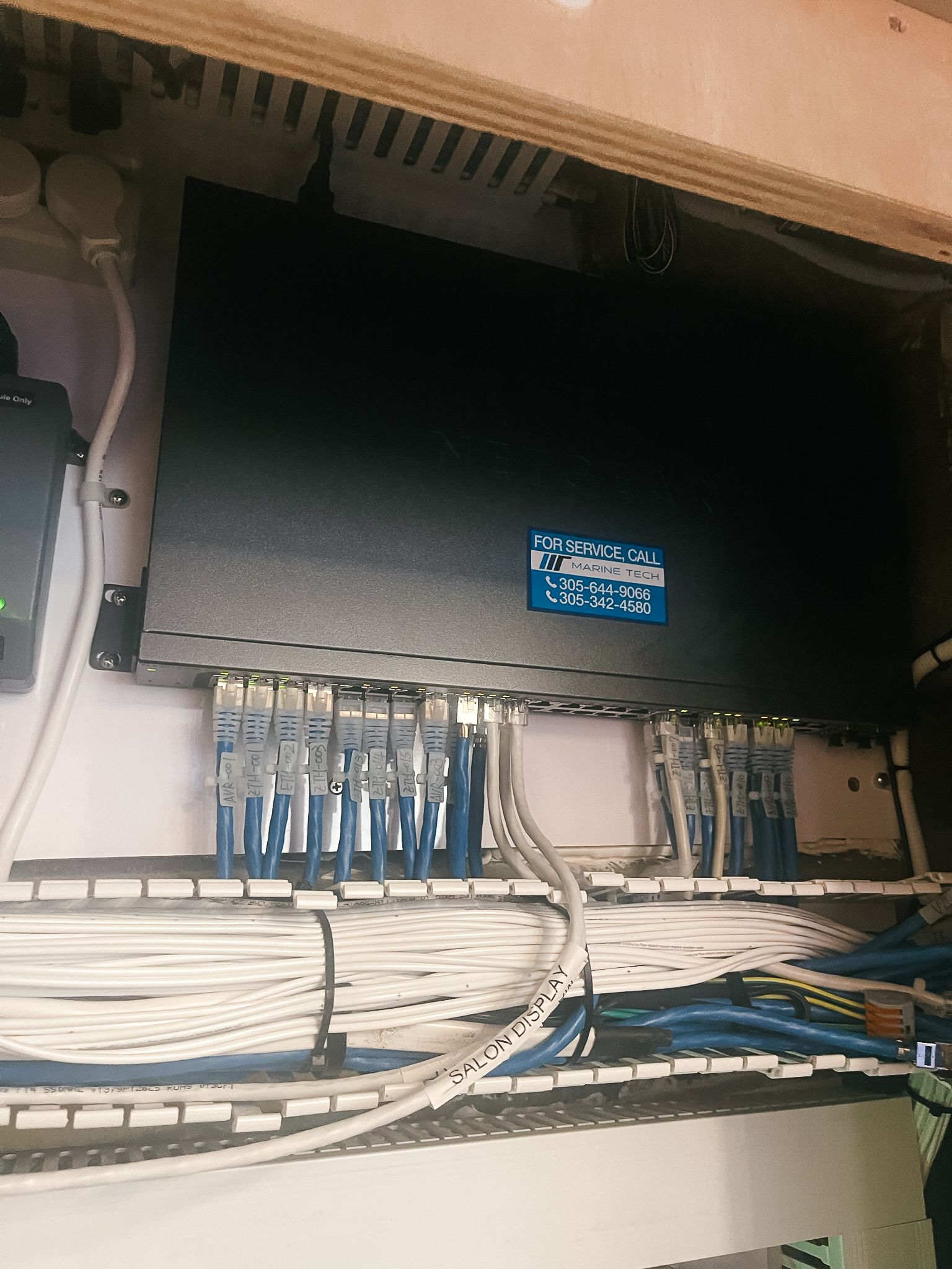 A black box with a blue sticker on it is connected to a bunch of wires.