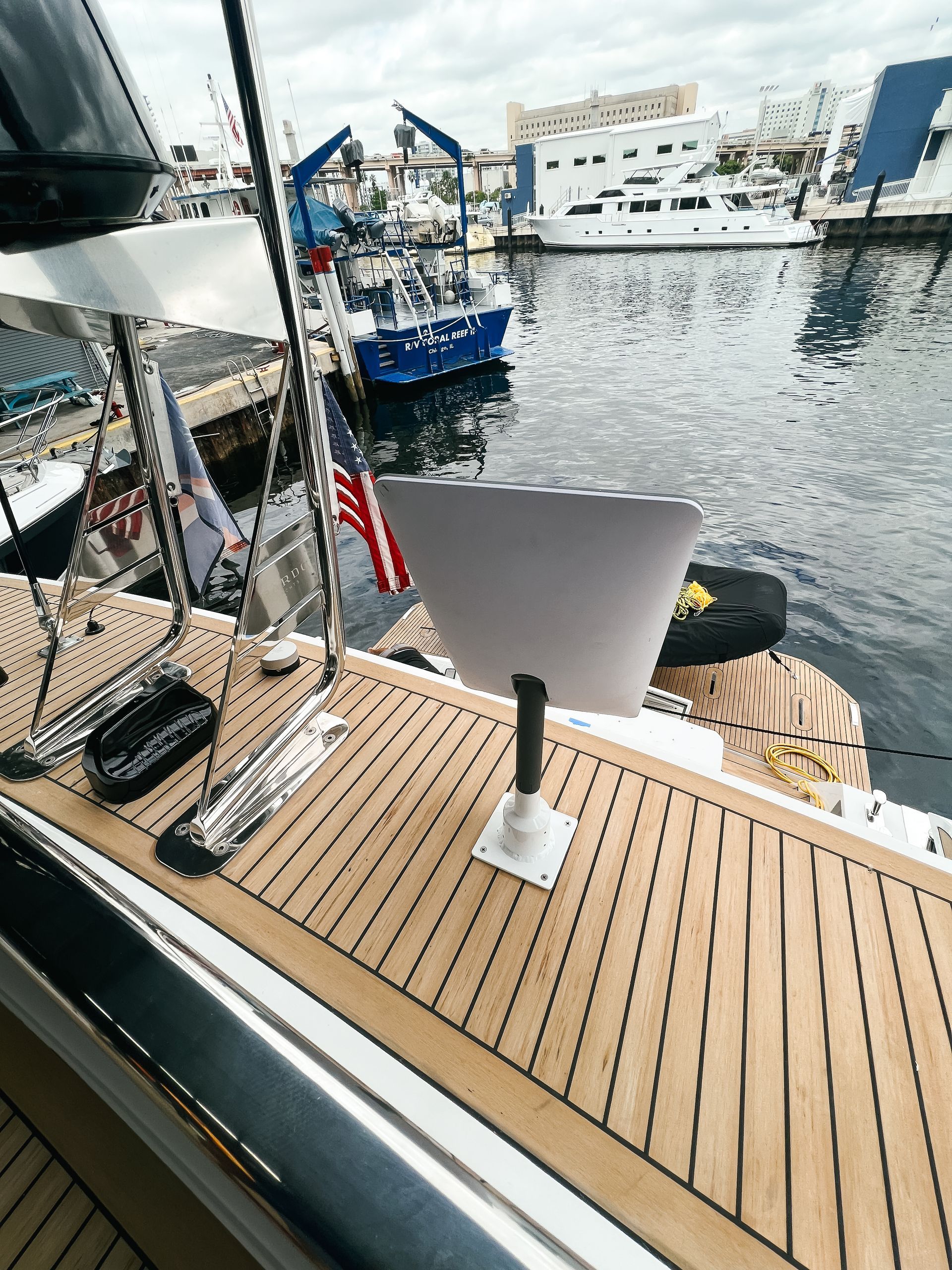 A laptop is sitting on the deck of a boat in the water.