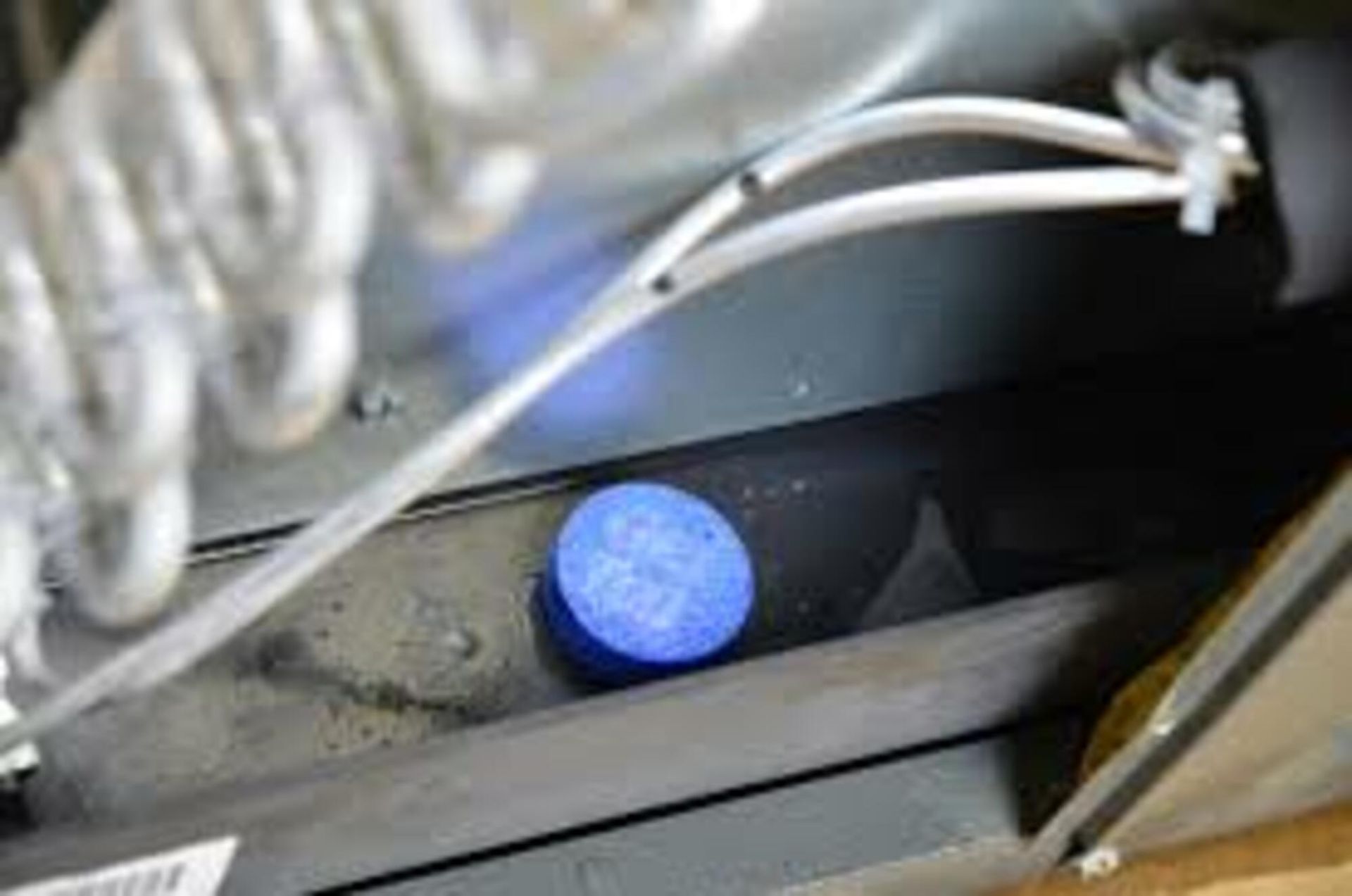 A blue bottle is sitting inside of a refrigerator.