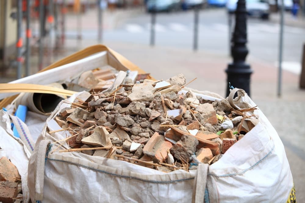 A Bag Filled with Bricks and Wood Is Sitting on The Sidewalk — Barry's Recycling in Brisbane, QLD
