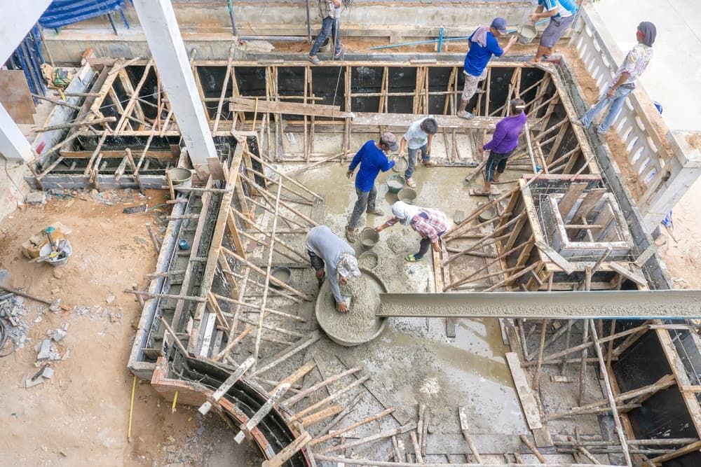 A Group of Construction Workers Are Working on The Foundation of A Building — Barry's Recycling in Ormeau, QLD