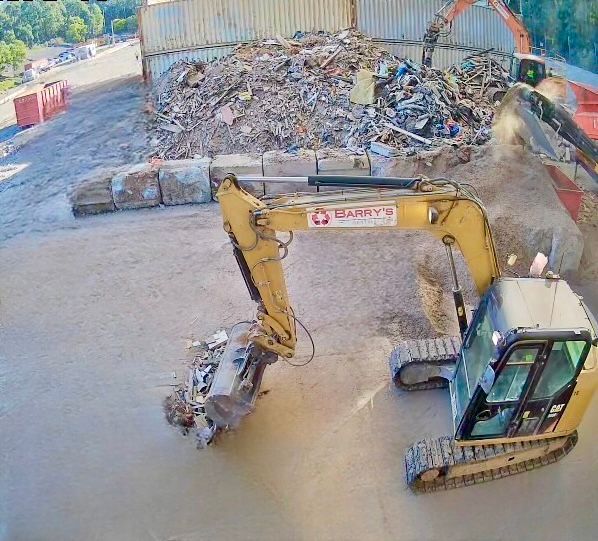 An Excavator Is Loading Dirt Into a Dump Truck — Barry's Recycling in Redland Bay, QLD