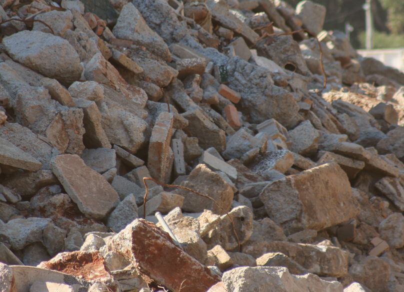 Pile of Bricks is Sitting in Front of a Building Under Construction — Barry's Recycling in Redland Bay, QLD